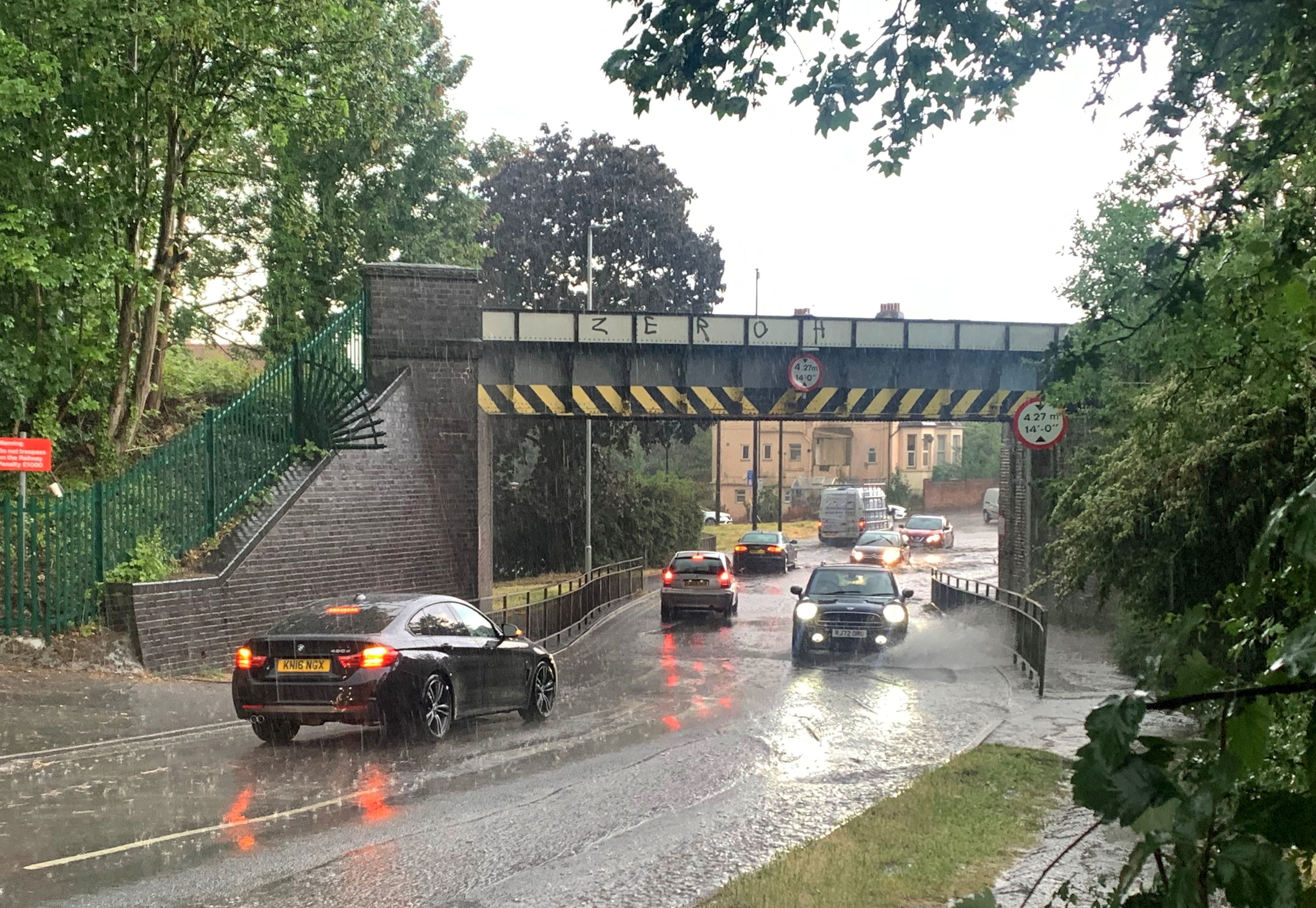 Cars driving through floodwater on Gringer Hill in Maidenhead