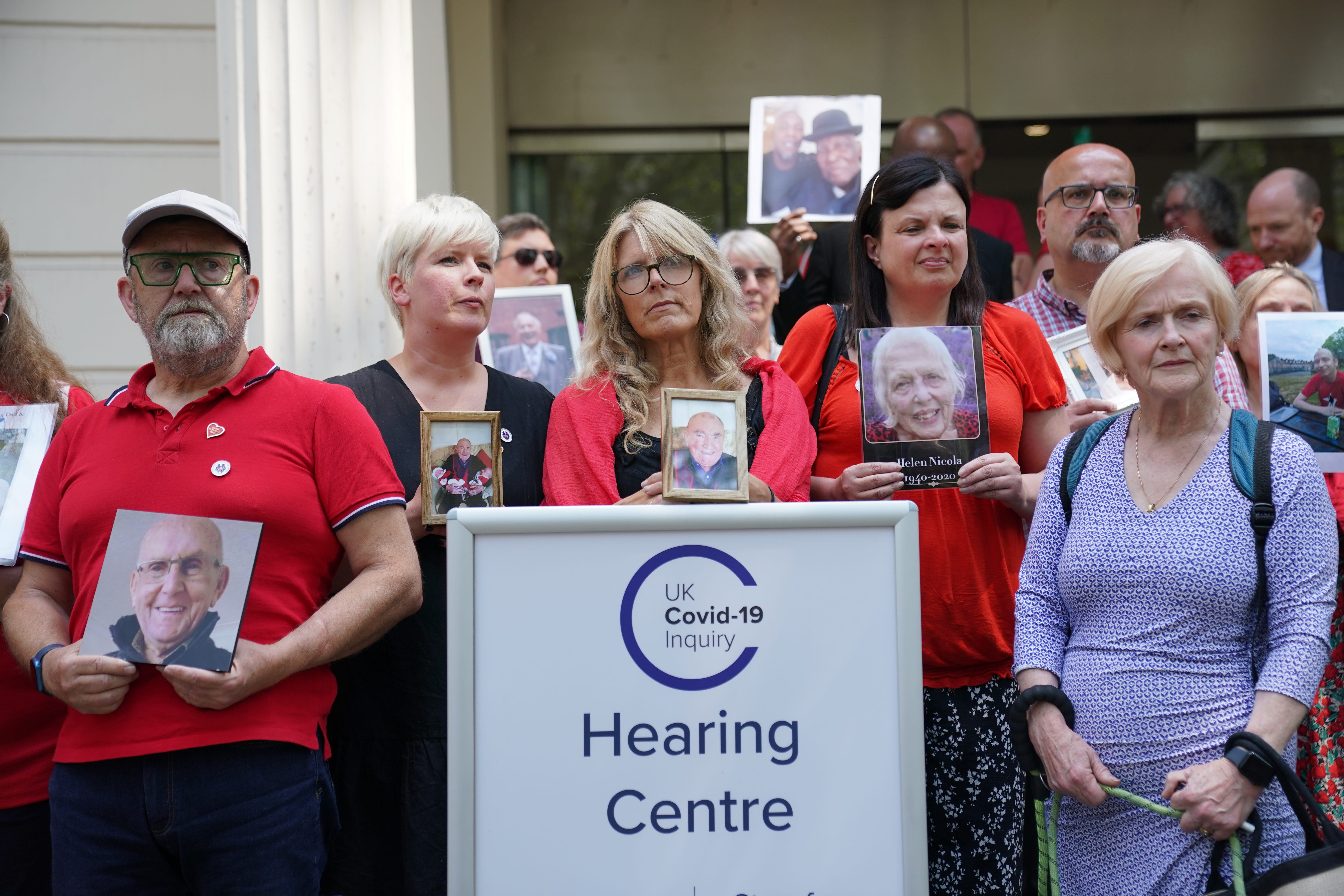 People hold pictures of loved ones lost during the pandemic outside Dorland House in London where the inquiry is hearing evidence for its first investigation (Module 1) examining if the pandemic was properly planned for and “whether the UK was adequately ready for that eventuality” (Lucy North/PA)