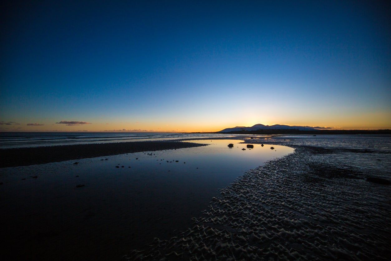 Tyrella Beach at sunset, with the Mourne Mountains in the background