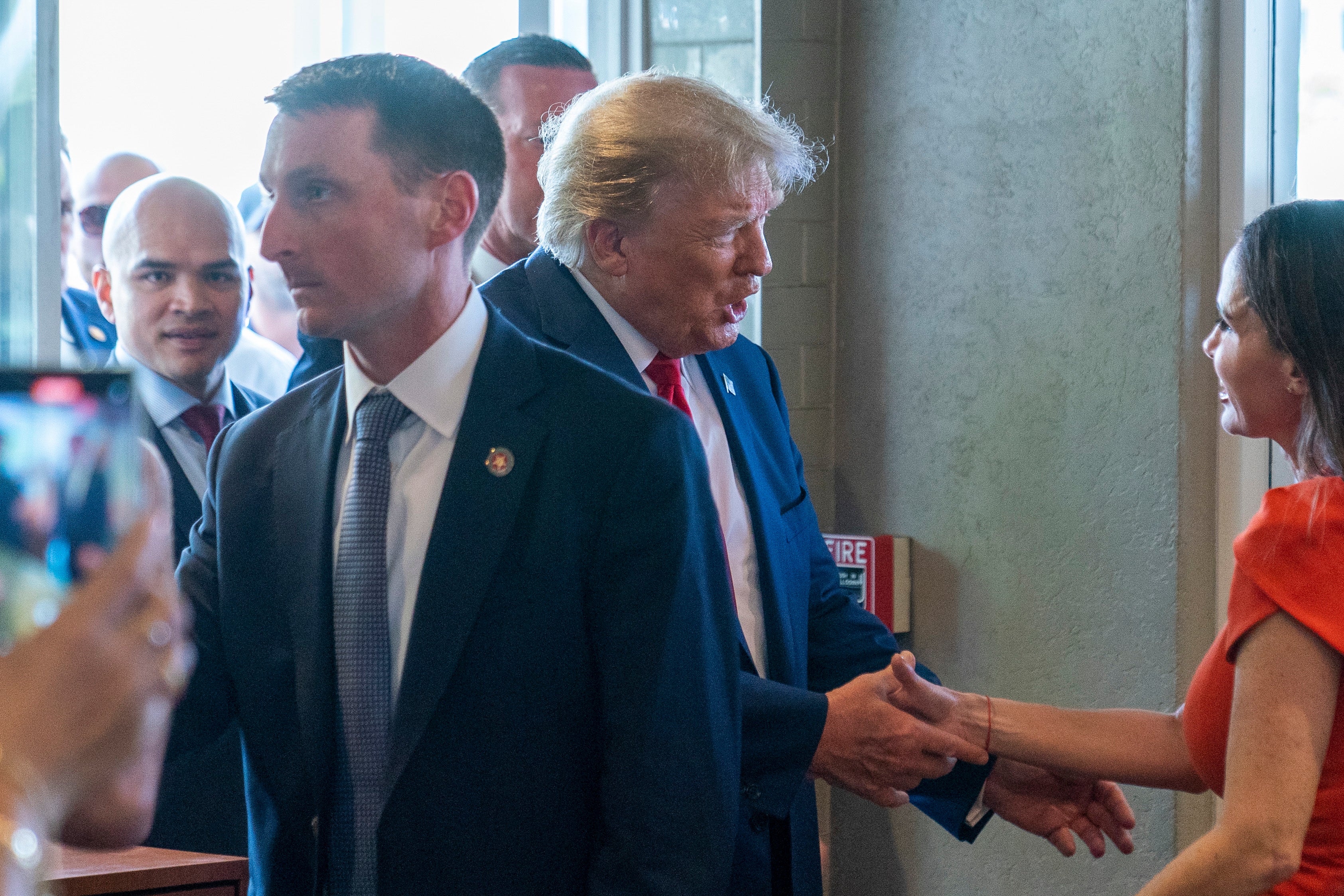 Walt Nauta, left, looks on as Donald Trump greets a supporter at the Versailles restaurant in Miami following their joint arraignment