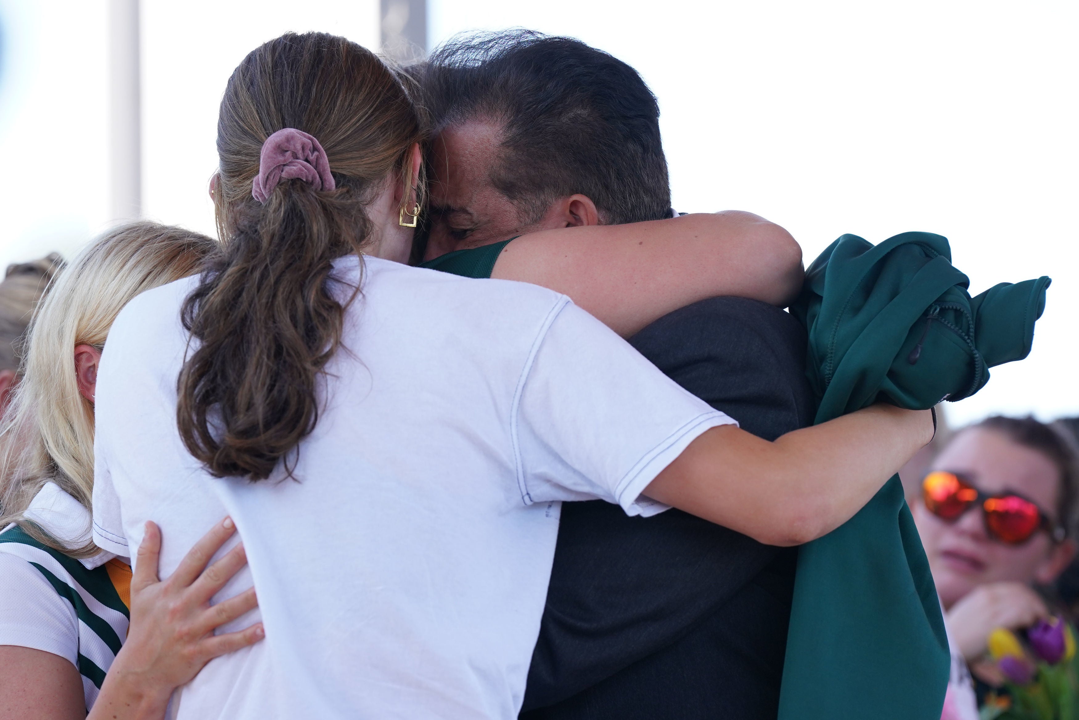 Grace’s father Sanjay Kumar hugs members of his daughter’s hockey team