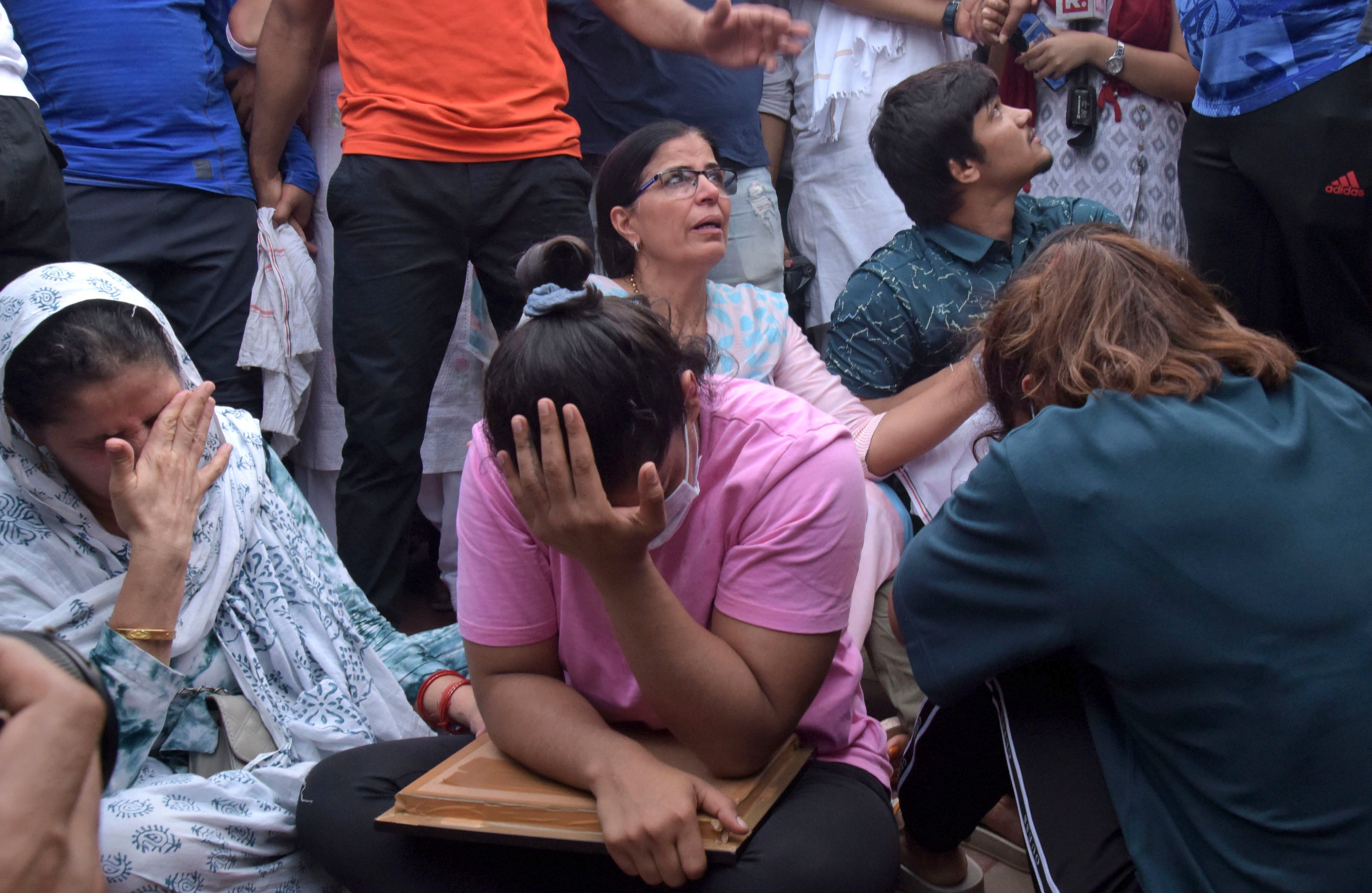 Sakshi Malik, an Indian wrestler who won a bronze medal at the 2016 Summer Olympics, sits with fellow wrestlers by the banks of the river Ganges in Haridwar, India, on 30 May 2023