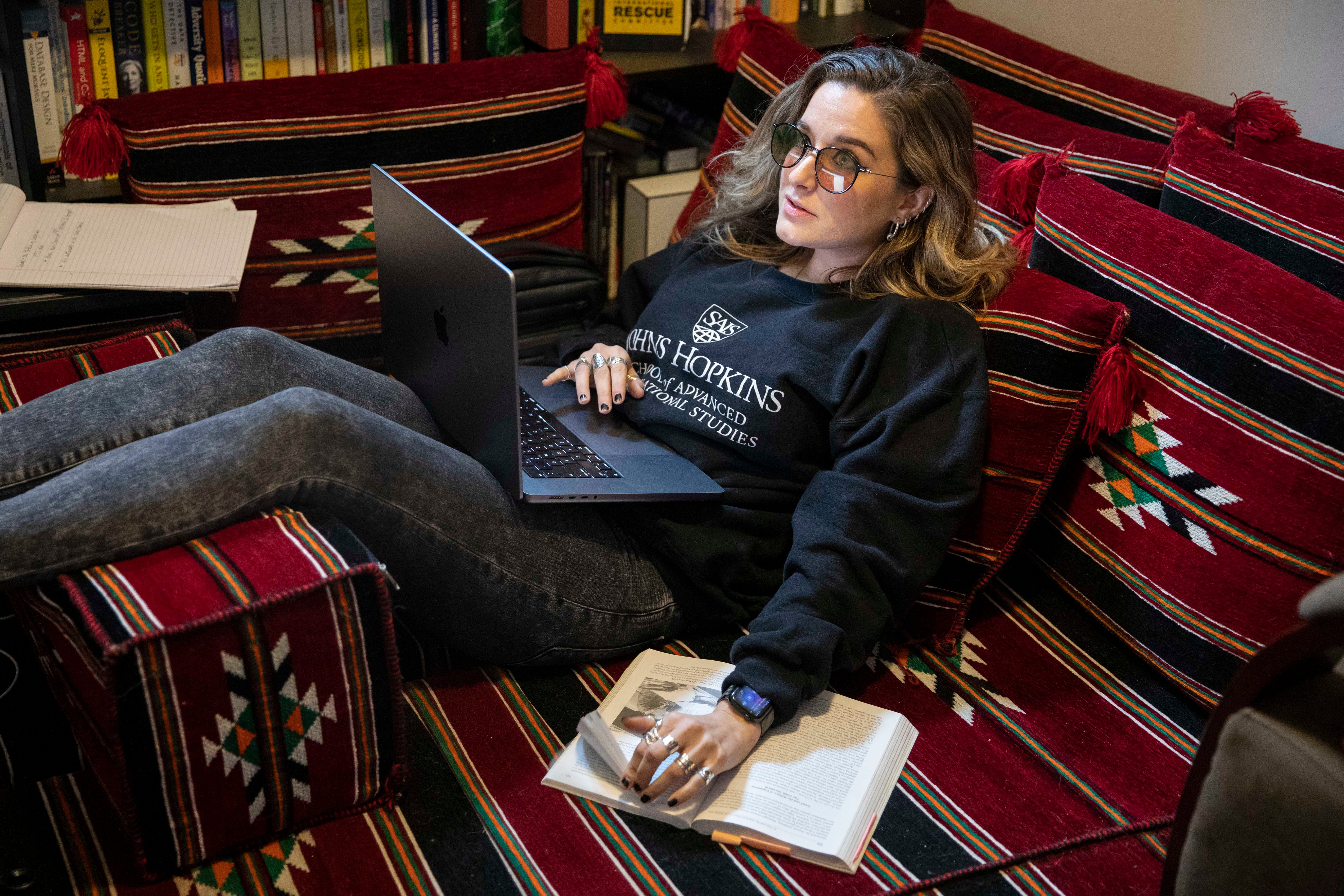 Amber studies at her DC home while wearing amber-toned glasses to dim the computer light and reduce vision issues