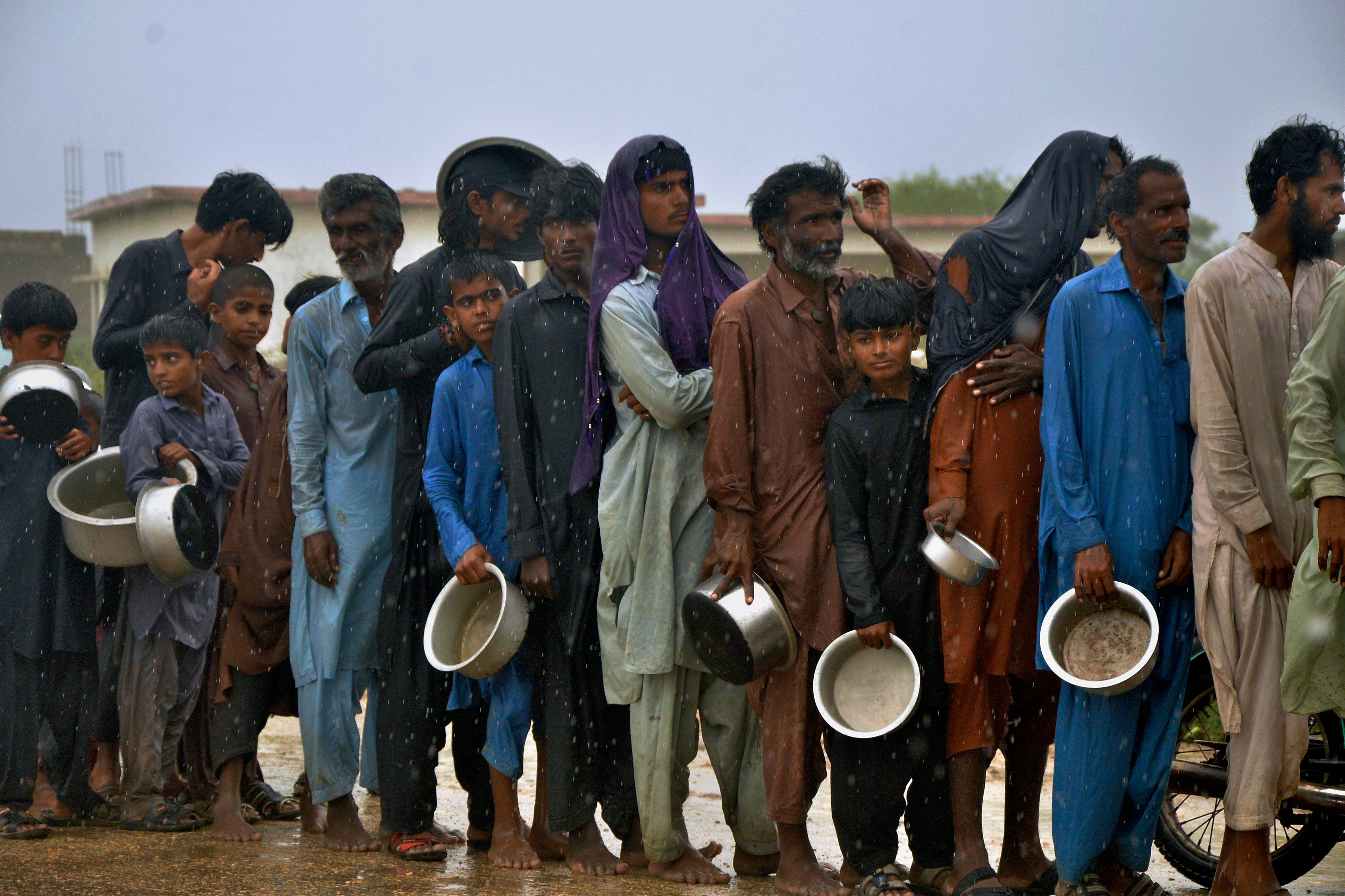 Evacuated people wait for food at a camp Sujawal, southern Pakistan