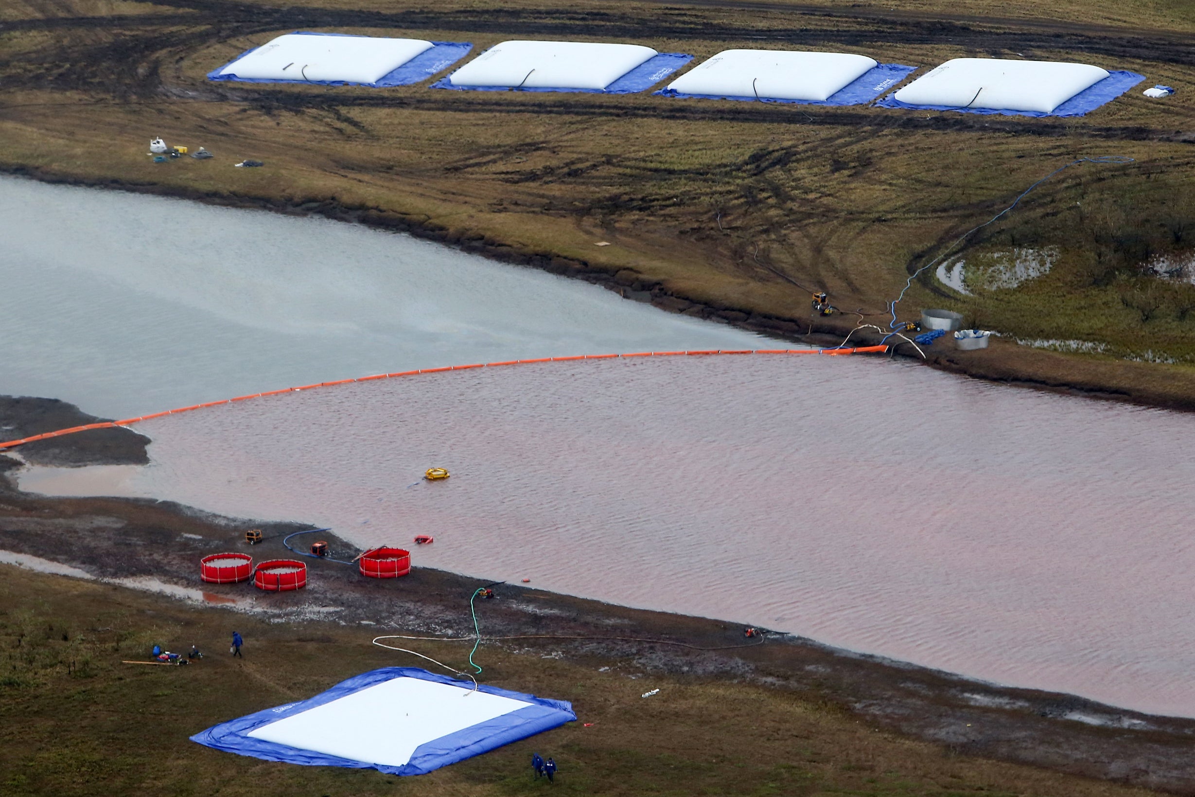 Employees of Russia’s state-owned oil pipeline monopoly Transneft take part in a clean-up operation following a massive fuel spill in the Ambarnaya River outside Norilsk in 2020