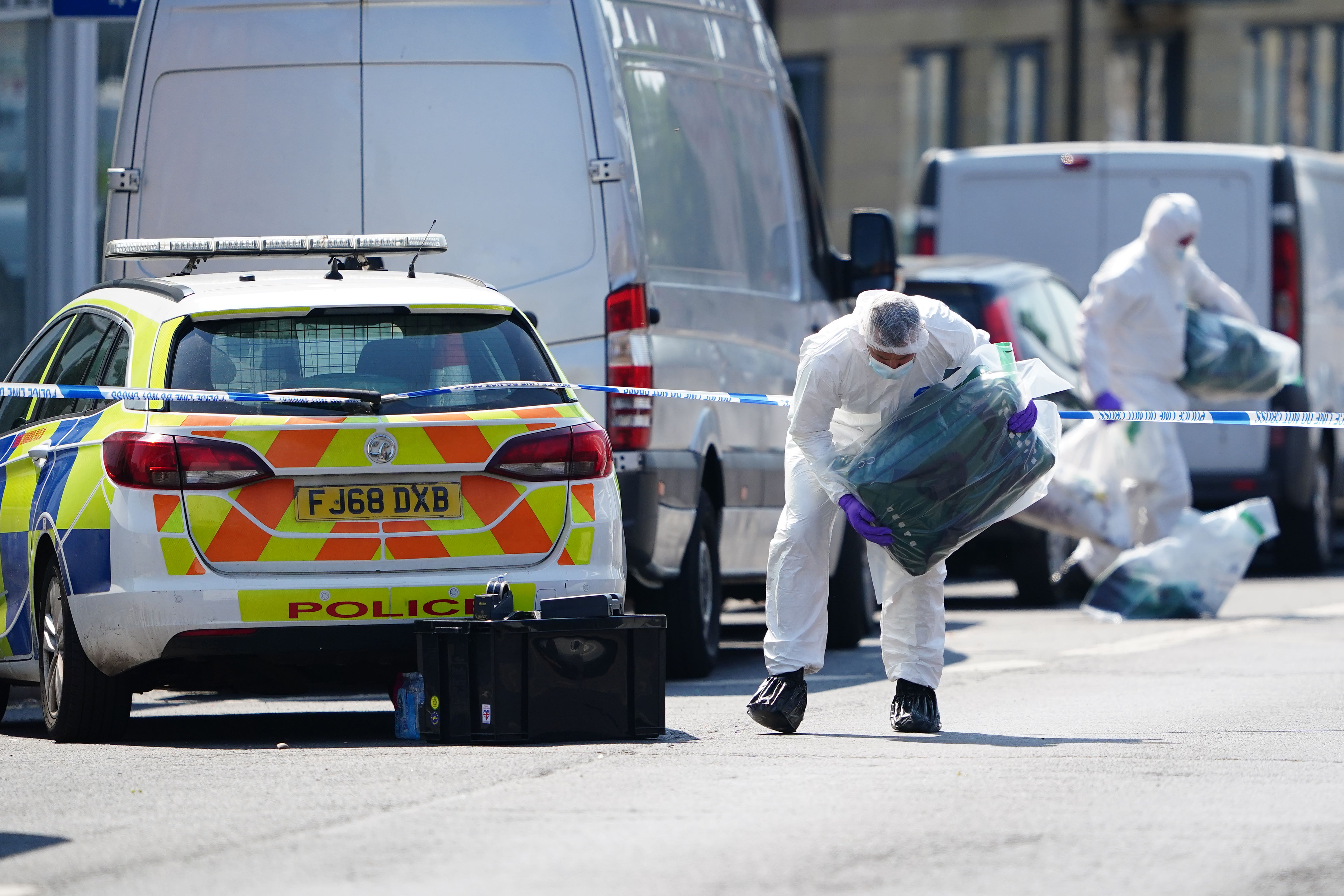 Police forensics officers on Ilkeston Road, Nottingham, as a 31-year-old man has been arrested on suspicion of murder after three people were killed on Tuesday morning (PA)