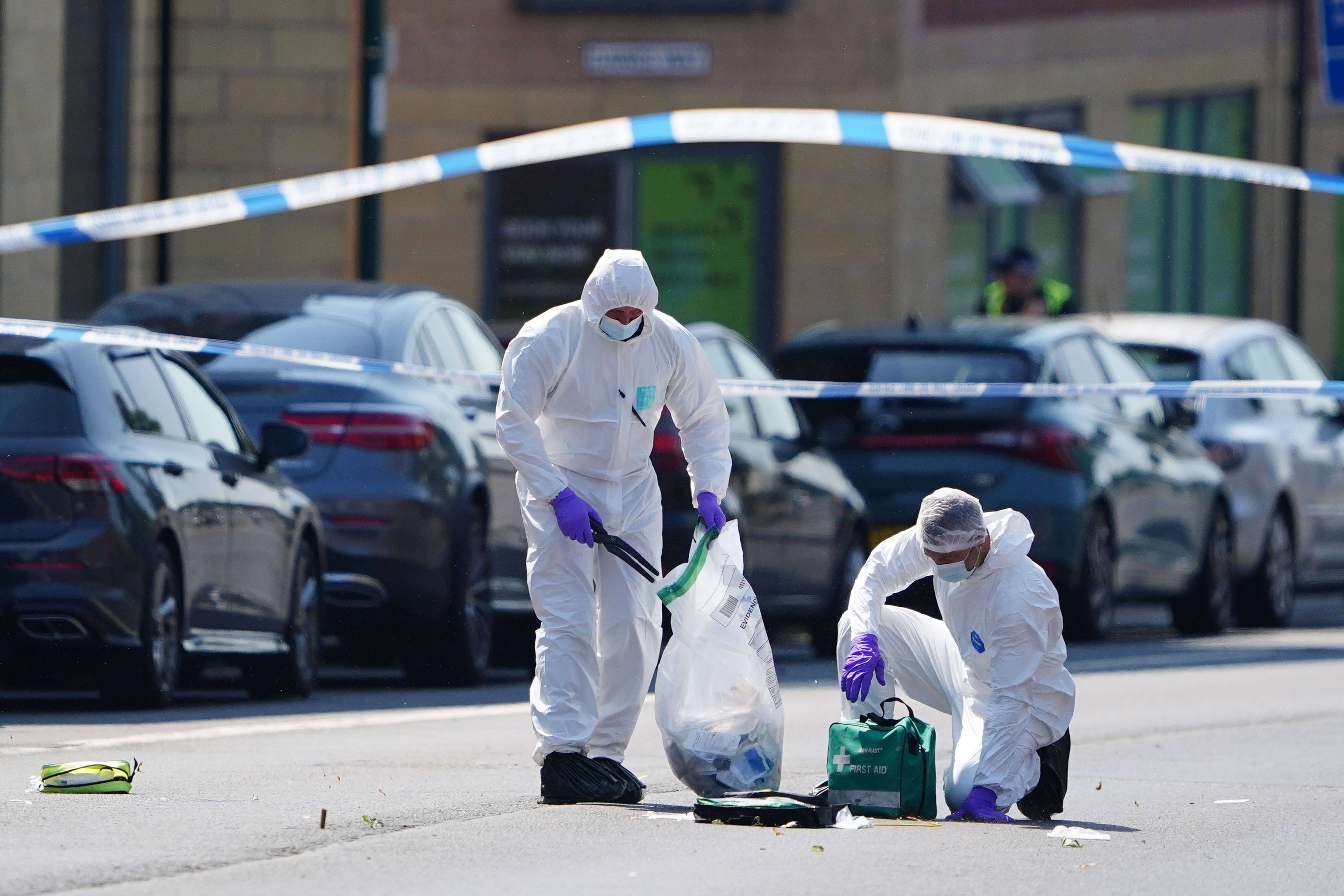 Police forensics officers on Ilkeston Road, Nottingham (PA)