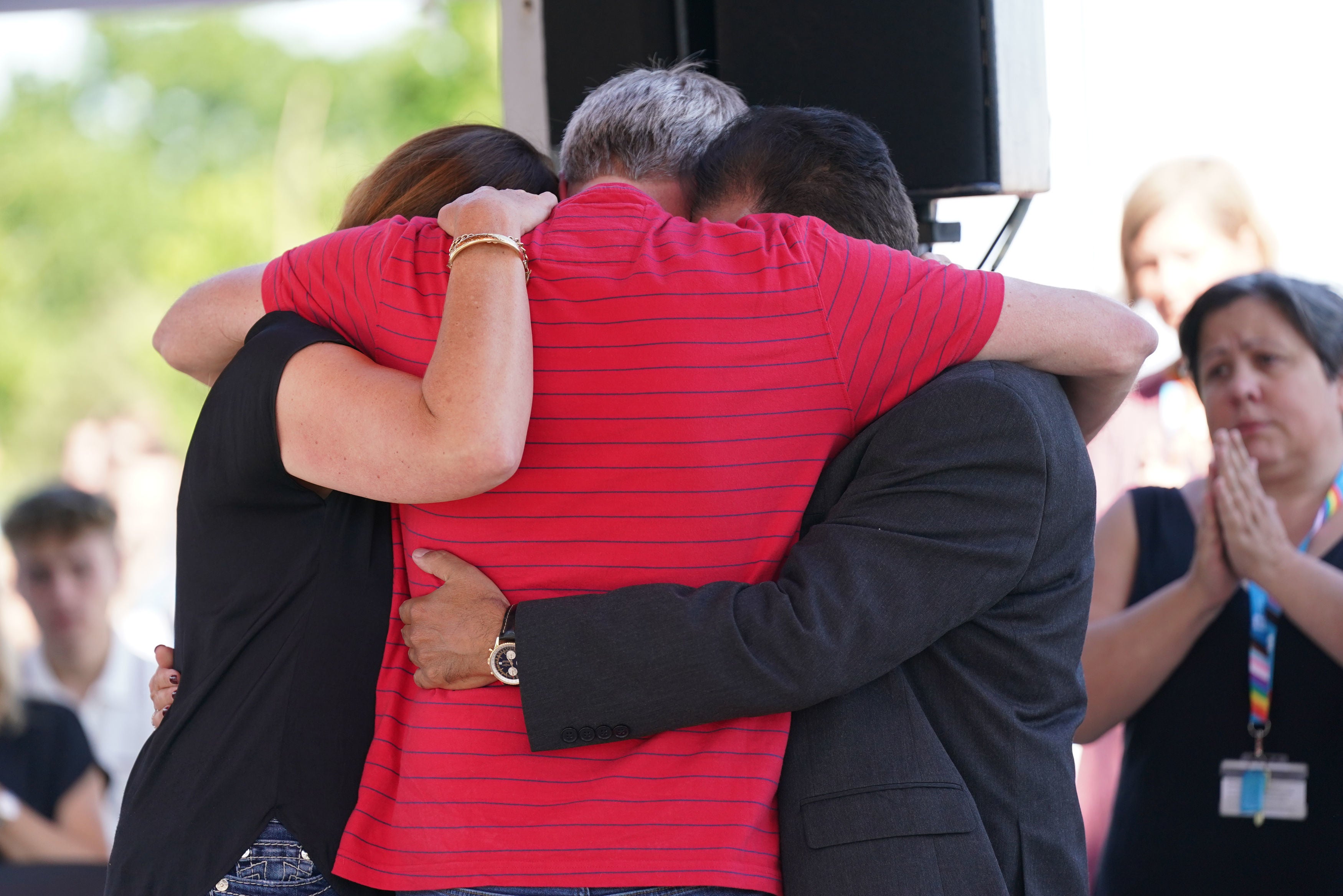 Grace O'Malley-Kumar's father, right, and Barnaby Webber's parents embrace during a vigil at the University of Nottingham