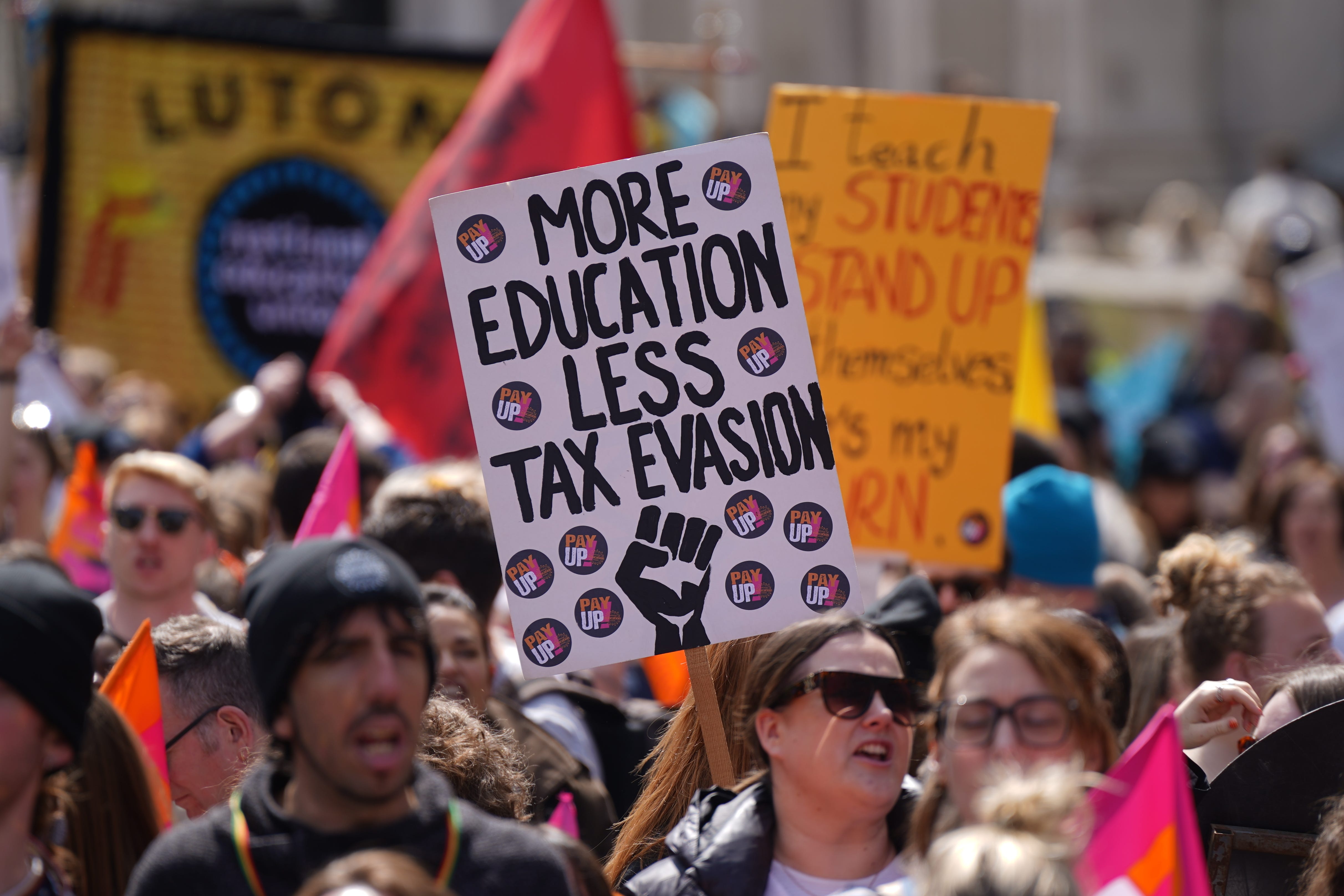 People listen to Kevin Courtney, Joint General Secretary National Education Union speaking at a rally in Westminster, London (PA)