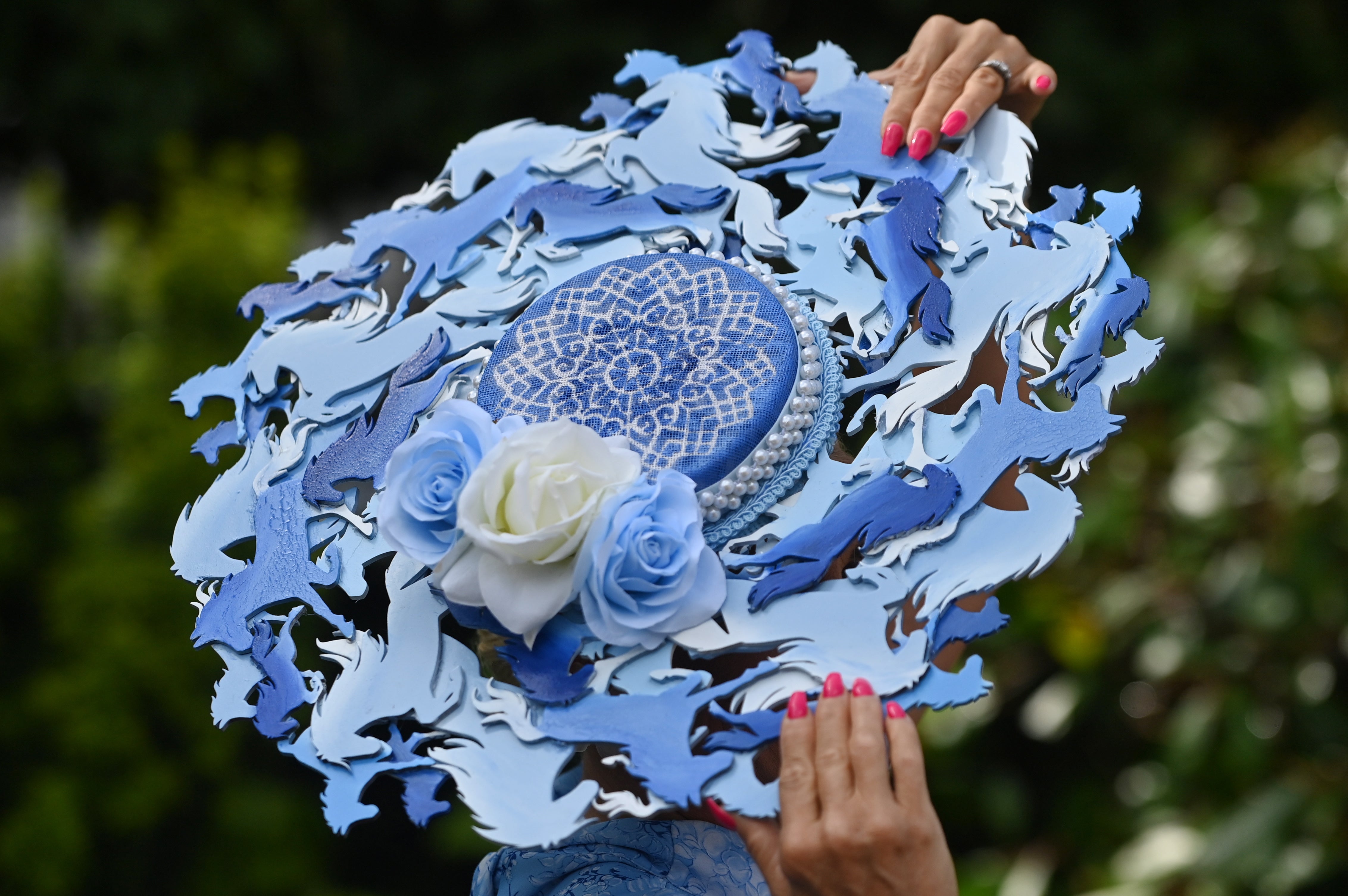 A race-goer with a horse themed hat attends day one of Royal Ascot