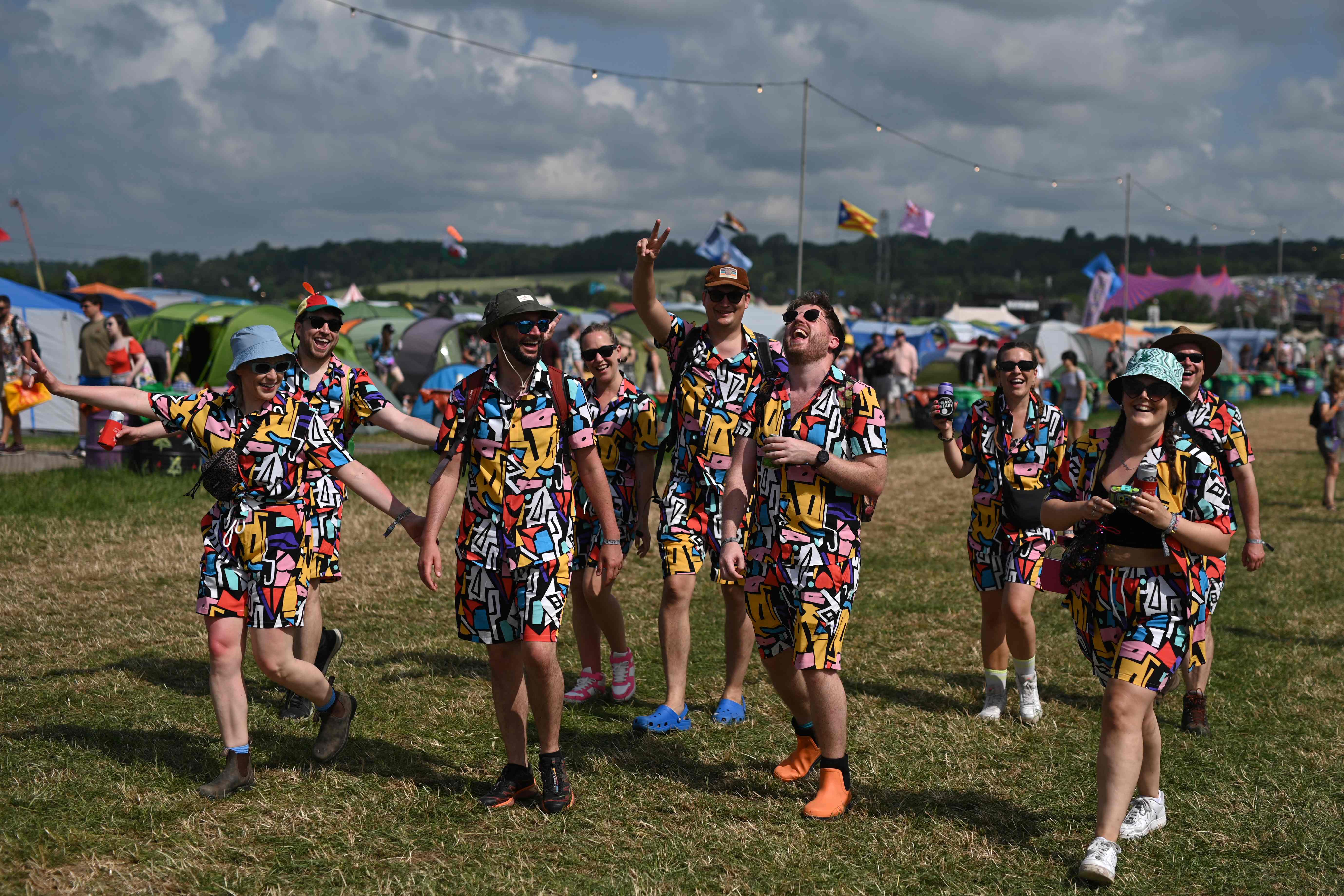 Festivalgoers enjoy the summer sunshine on day two of the Glastonbury festival in the village of Pilton in Somerset