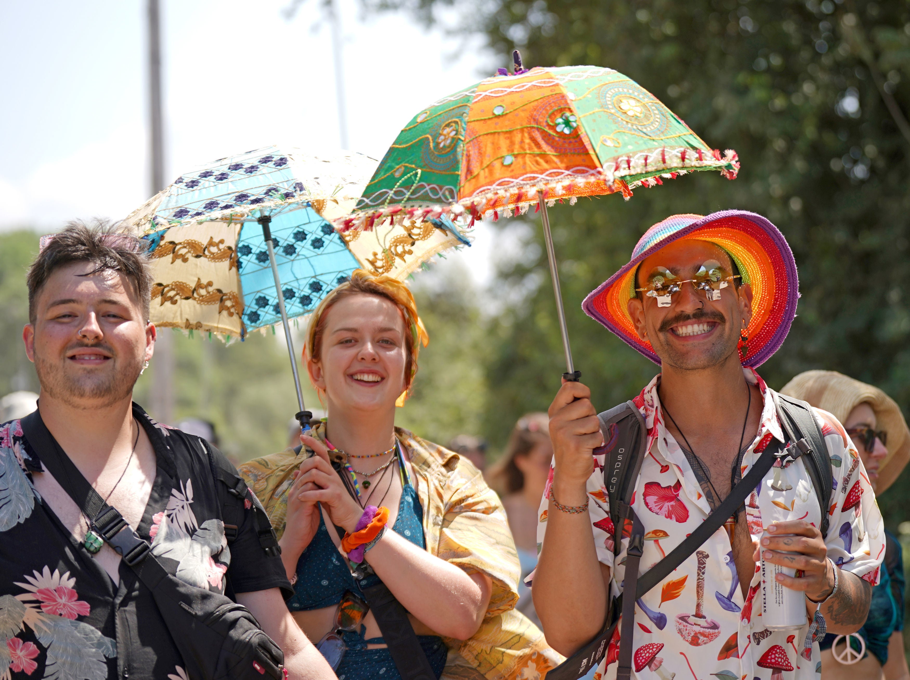 Festivalgoers use parasols to shelter from the sun at the Glastonbury Festival at Worthy Farm