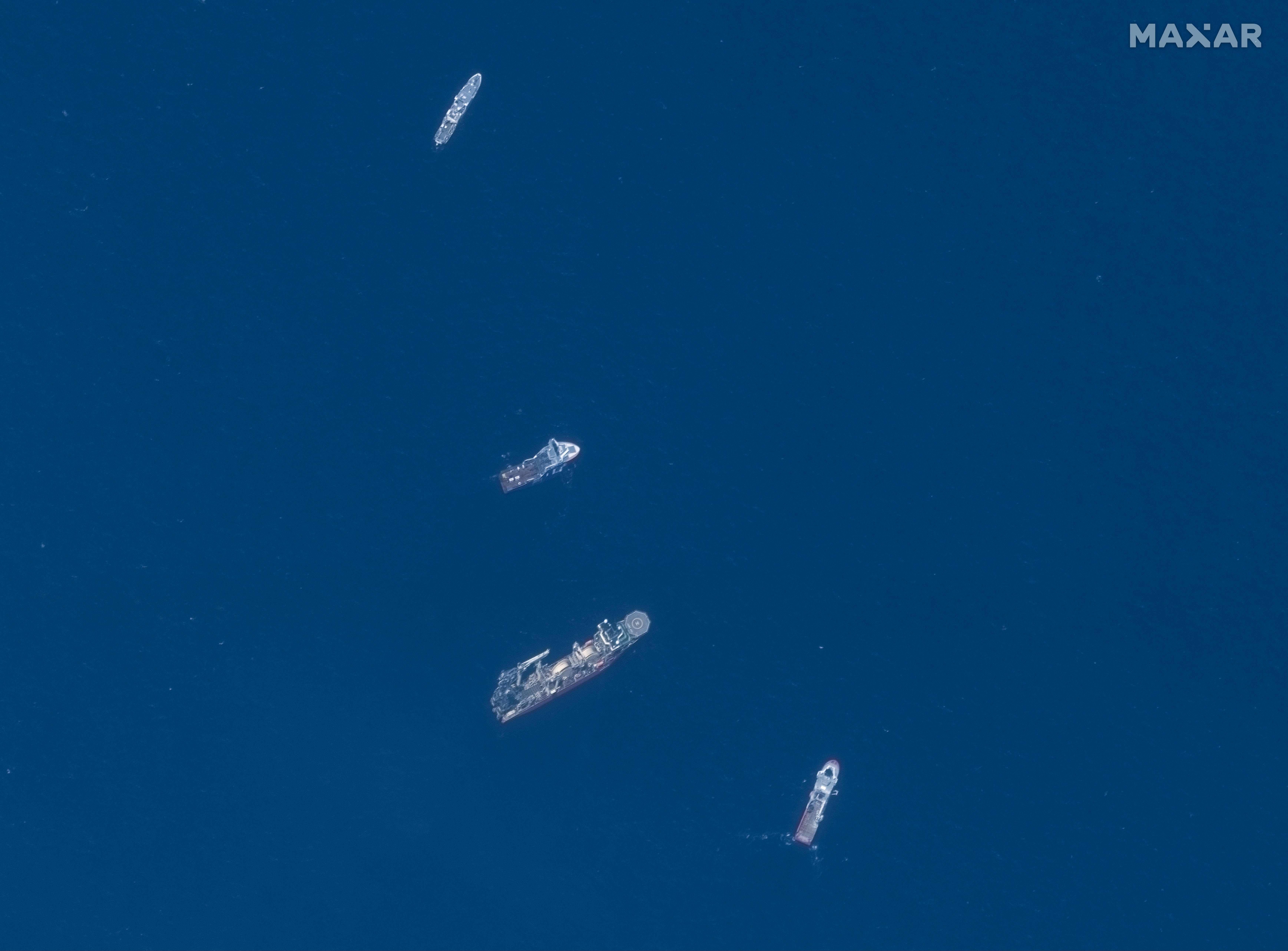 This June 22, 2023, satellite image courtesy of Maxar Technologies shows the Horizon Arctic (2nd from top), Deep Energy (C) and Skandi Vinland (bottom) searching on Thursday for the missing Titan submersible