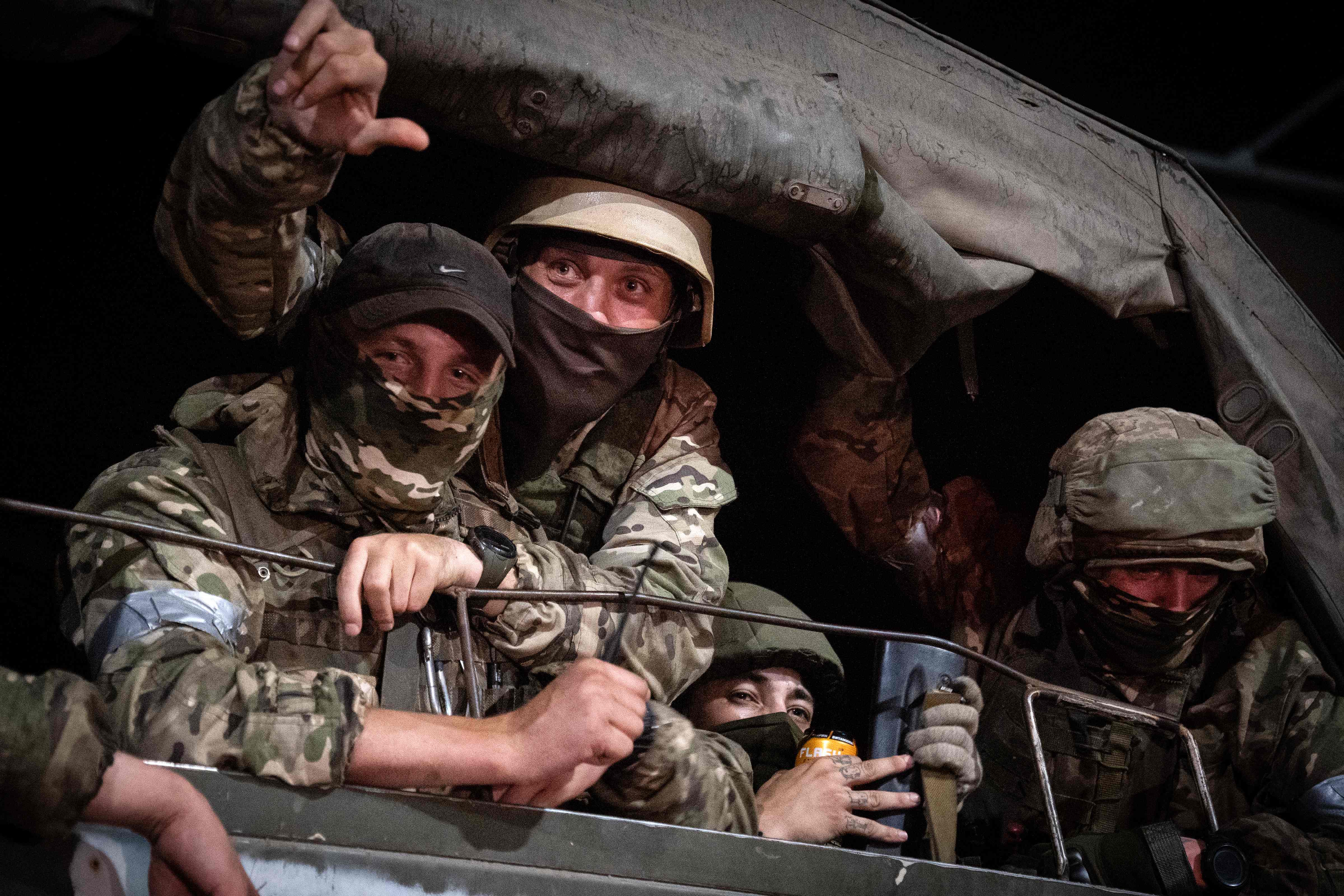 Members of Wagner group look from a military vehicle in Rostov-on-Don