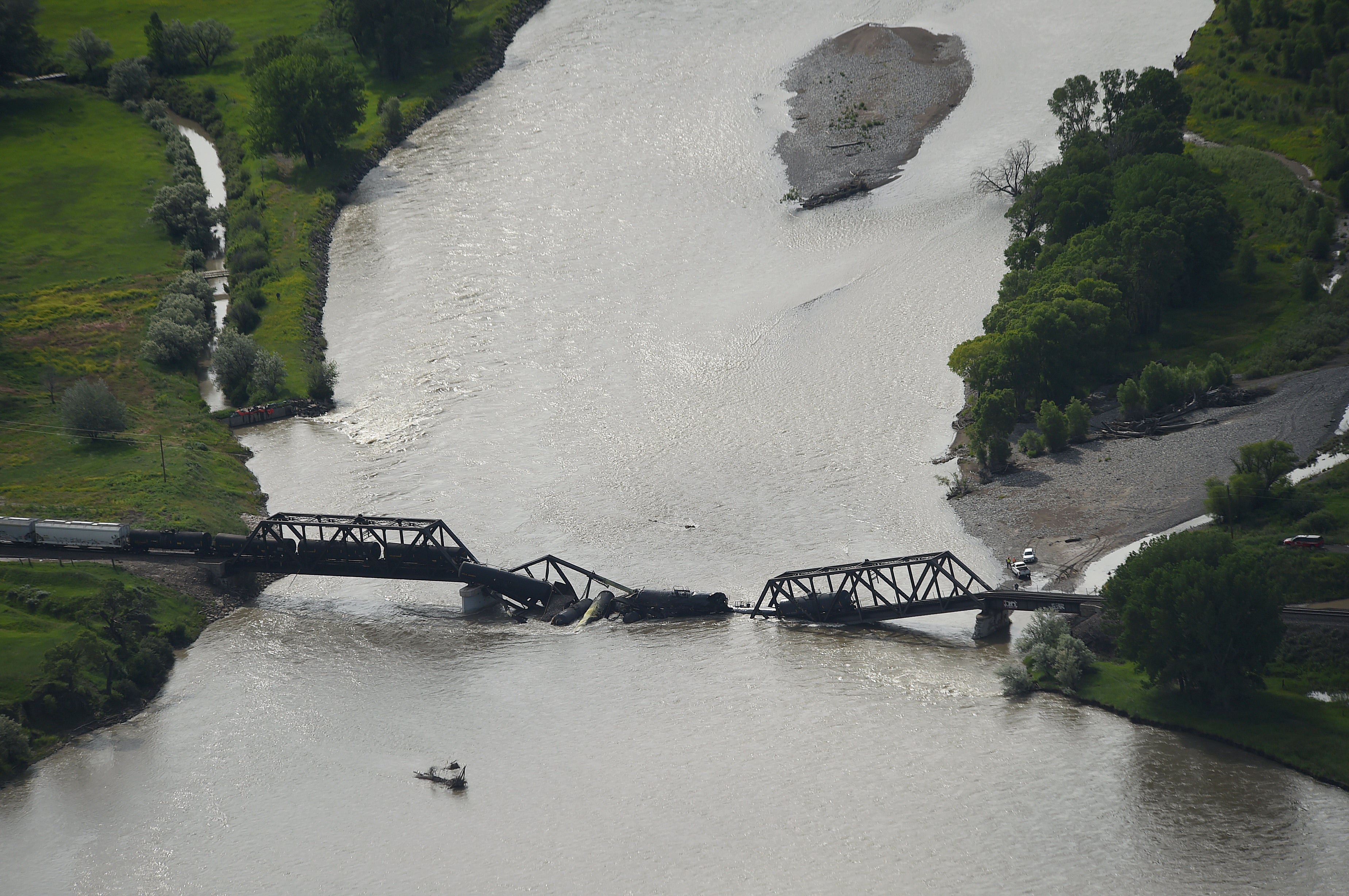 Portions of a freight train are seen in the Yellowstone River after an overnight railroad bridge collapse, near Columbus, Mont., Saturday, June 24, 2023.