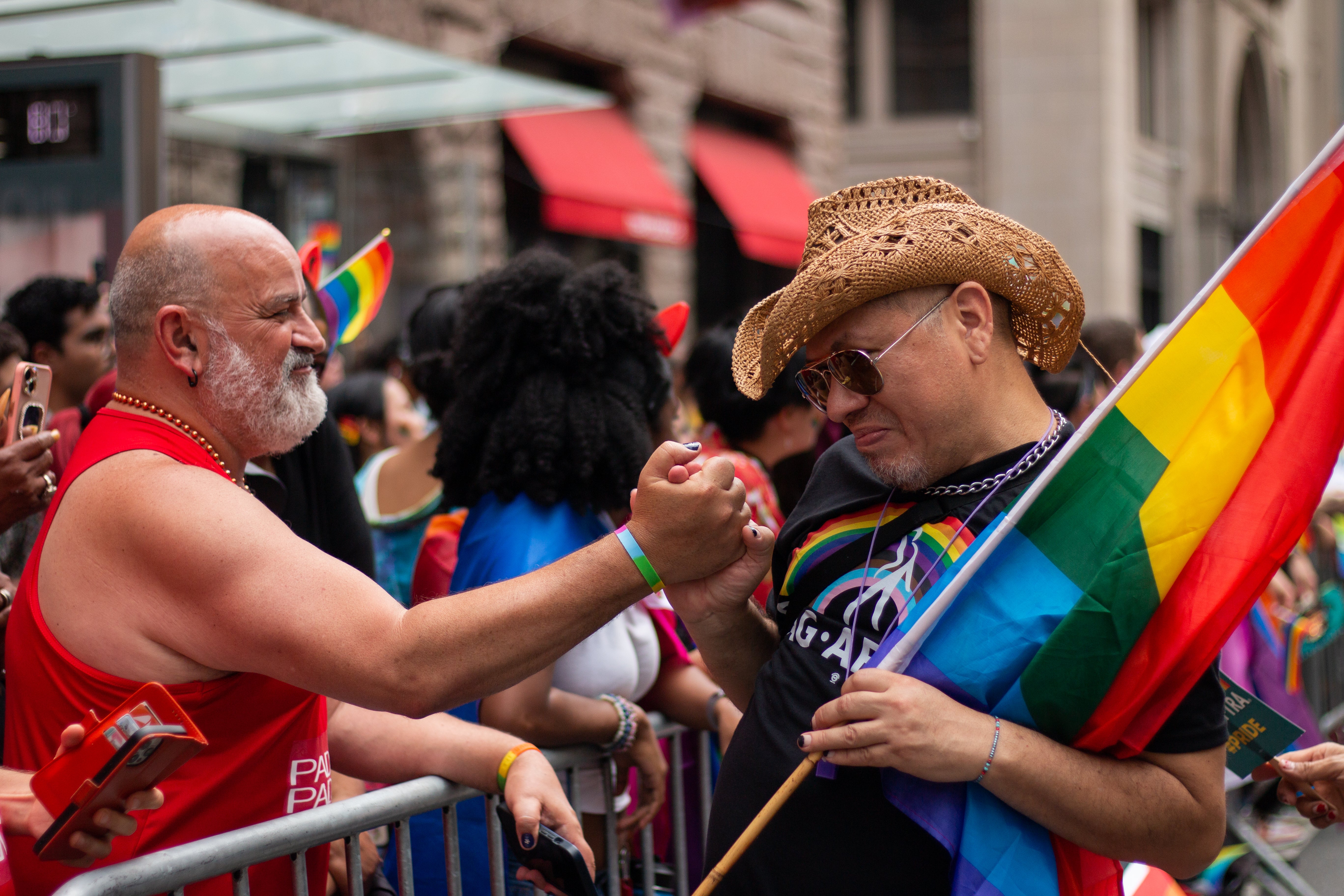 A Pride March attendee and marcher hold hands in New York City