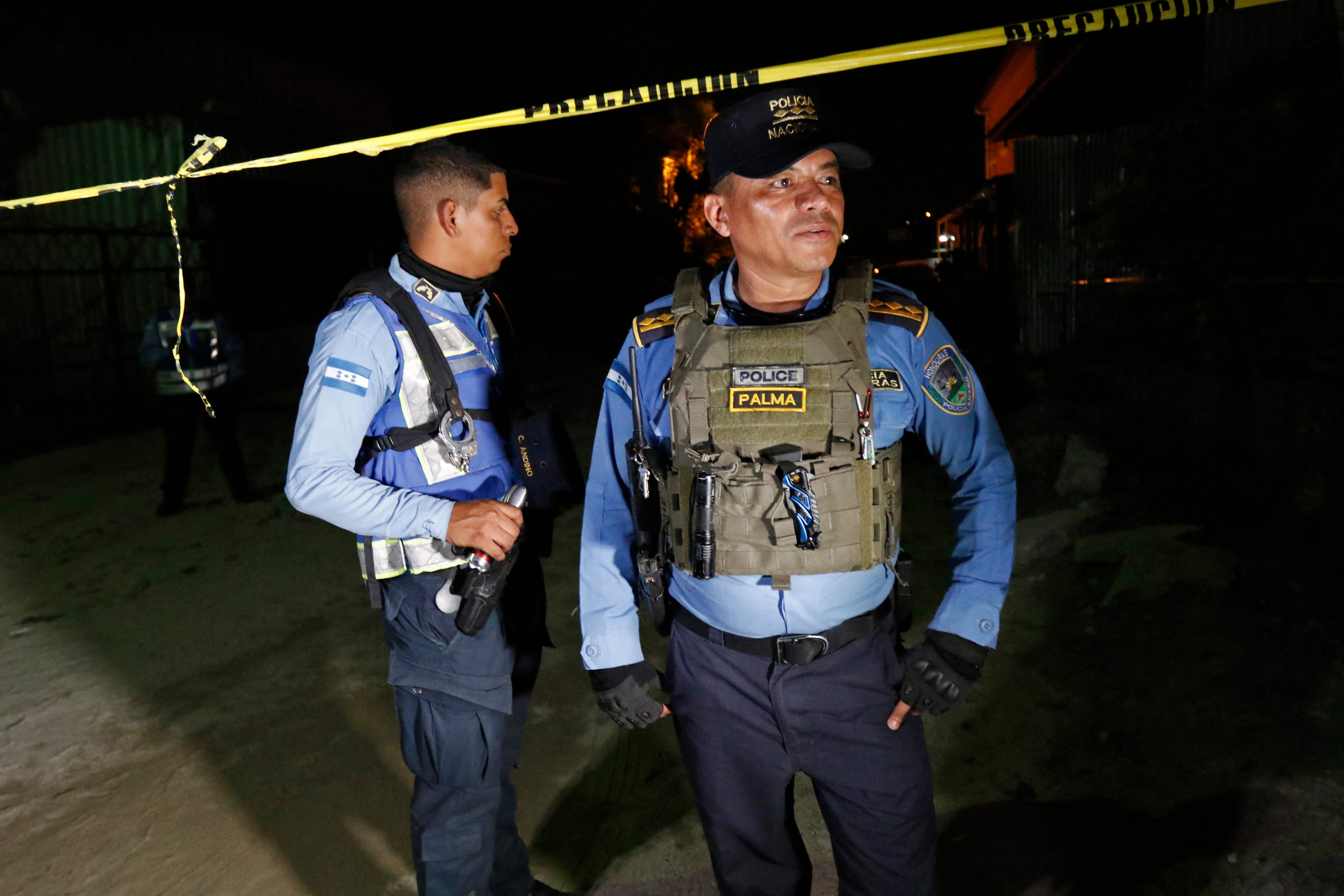 National Police officers stand guard outside a pool hall after eleven people were killed, in Choloma