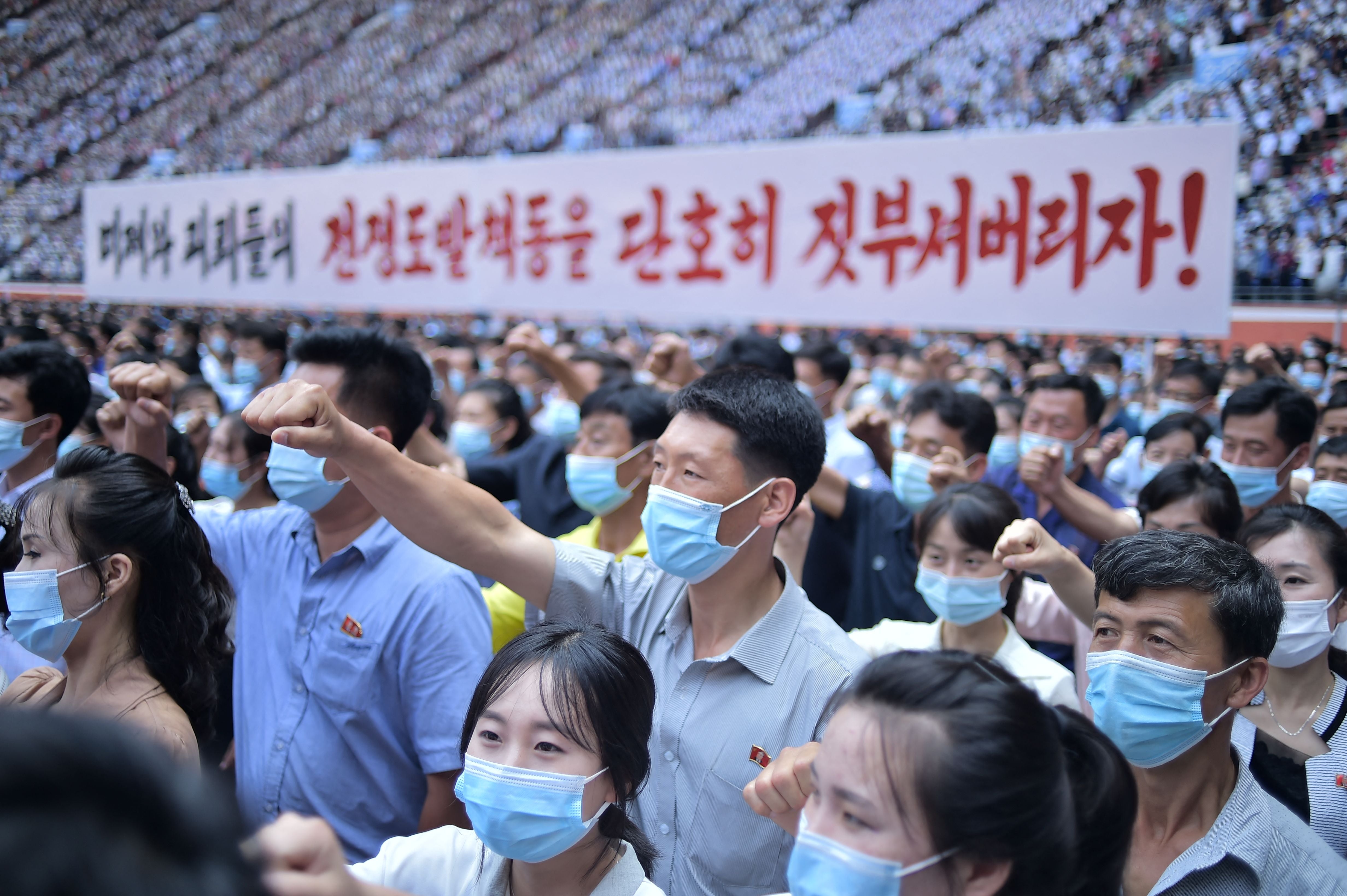 residents of Pyongyang hold a banner that reads "Let us smash down the war provocation of US imperialists and puppets!"