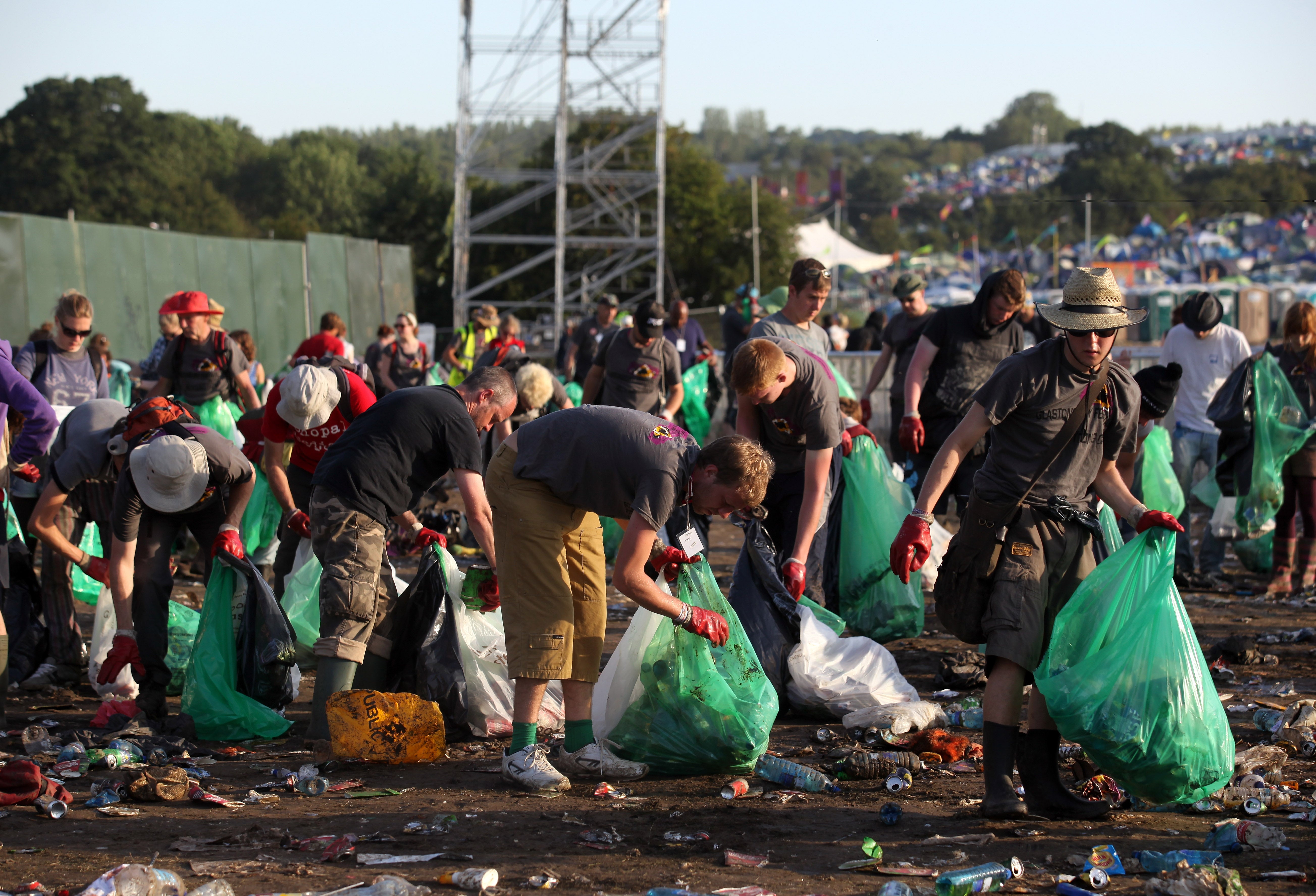 Festival litter pickers begin to clear the rubbish left in the main arena at the 2011 festival