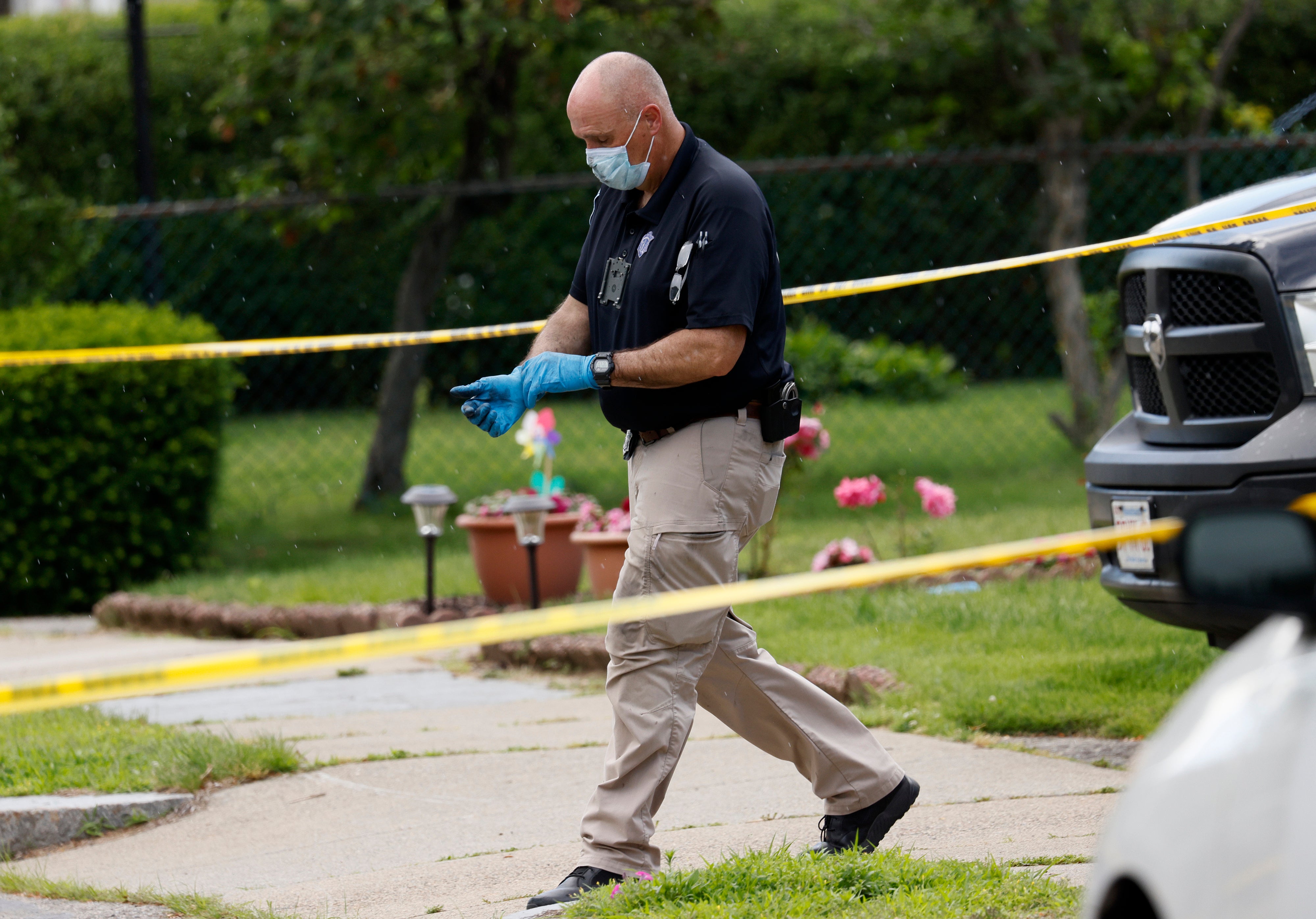 An investigator walks out of a home along Broadway Street, in Newton, Mass, on Sunday.