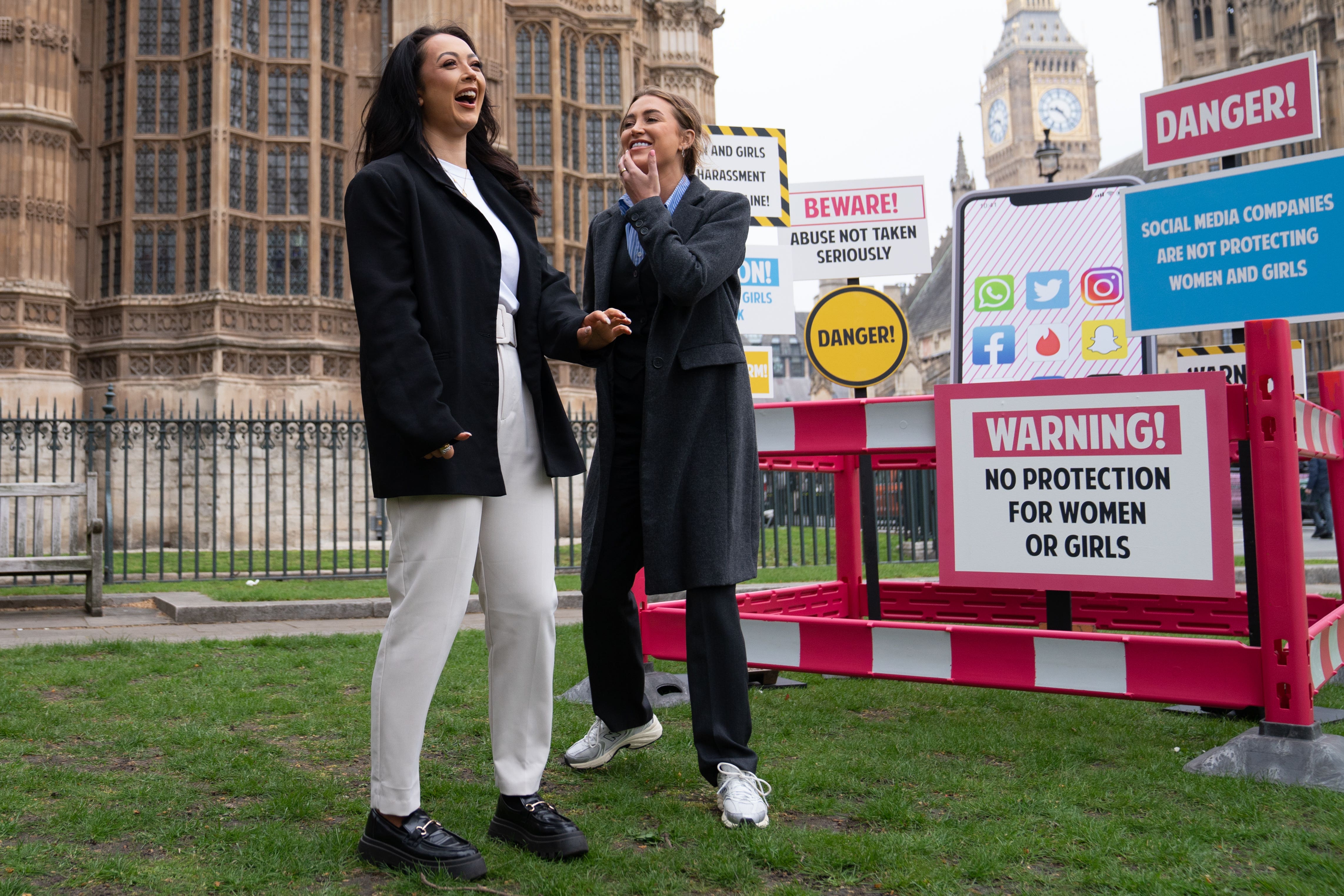 Love Island contestants Georgia Harrison, right, and Sharon Gaffka at a demonstration organised by Refuge outside the Houses of Parliament (PA)