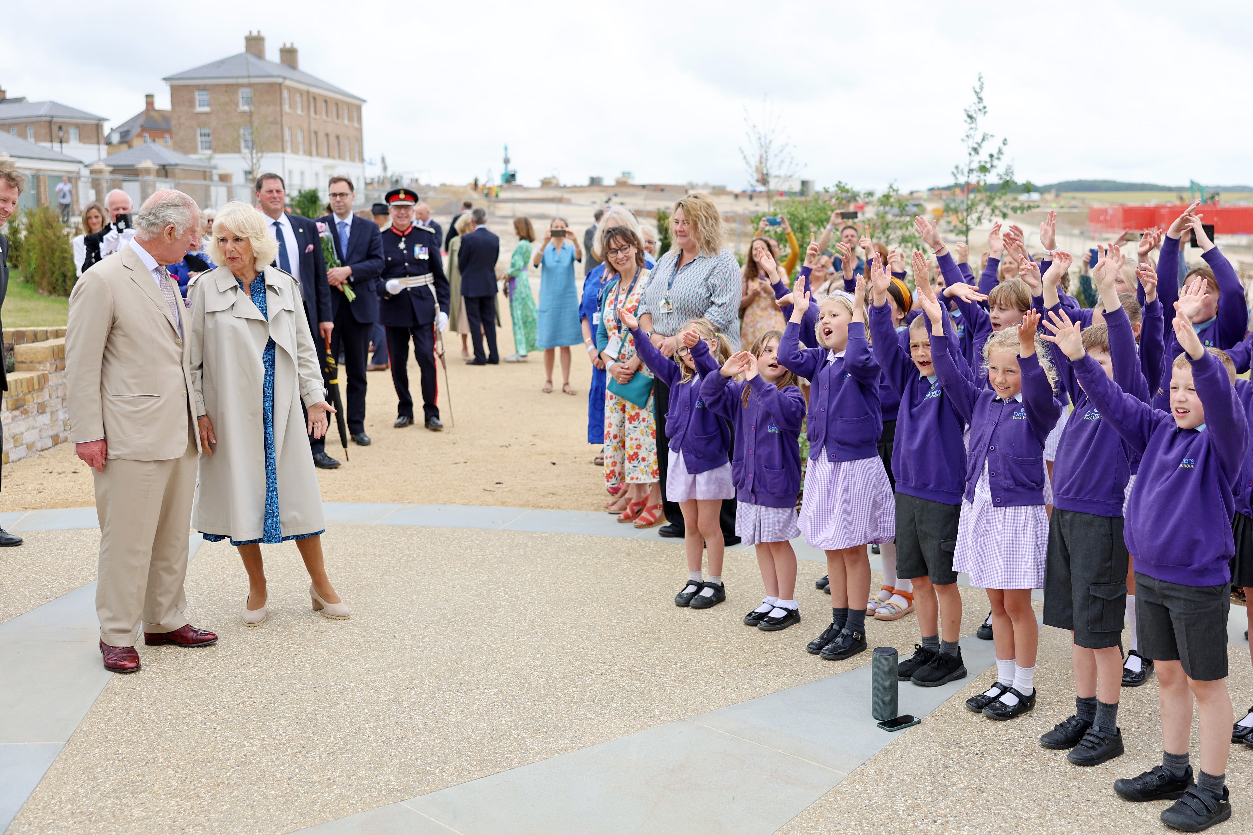 King Charles III and Queen Camilla listen to children from local Damers First School performing their Coronation song as they visit Poundbury at Poundbury