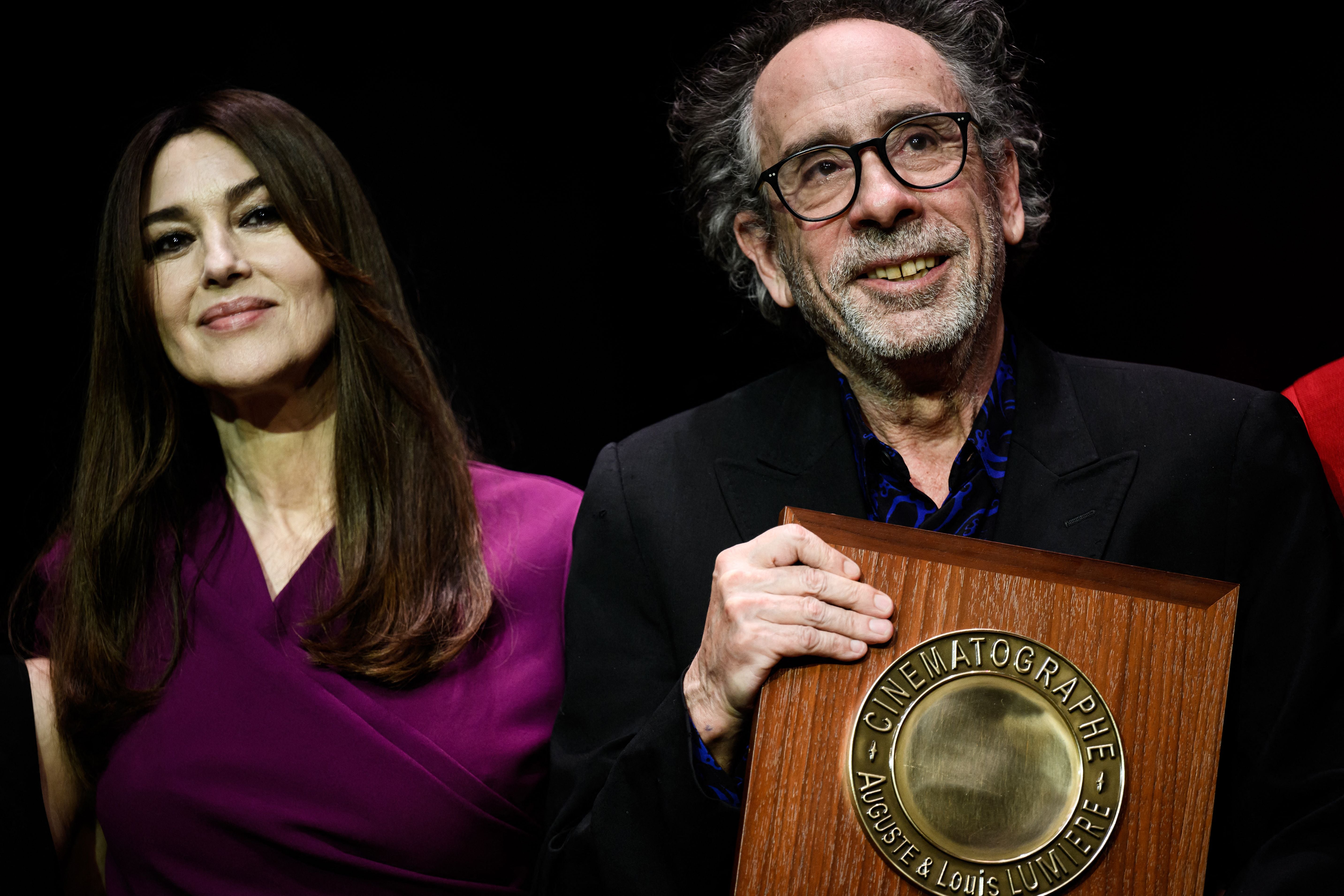 Tim Burton reacts as he receives the Lumiere Award from Italian actress Monica Bellucci during the award ceremony of the 14th edition of the Lumiere Film Festival in Lyon, central-eastern France, on October 21, 2022