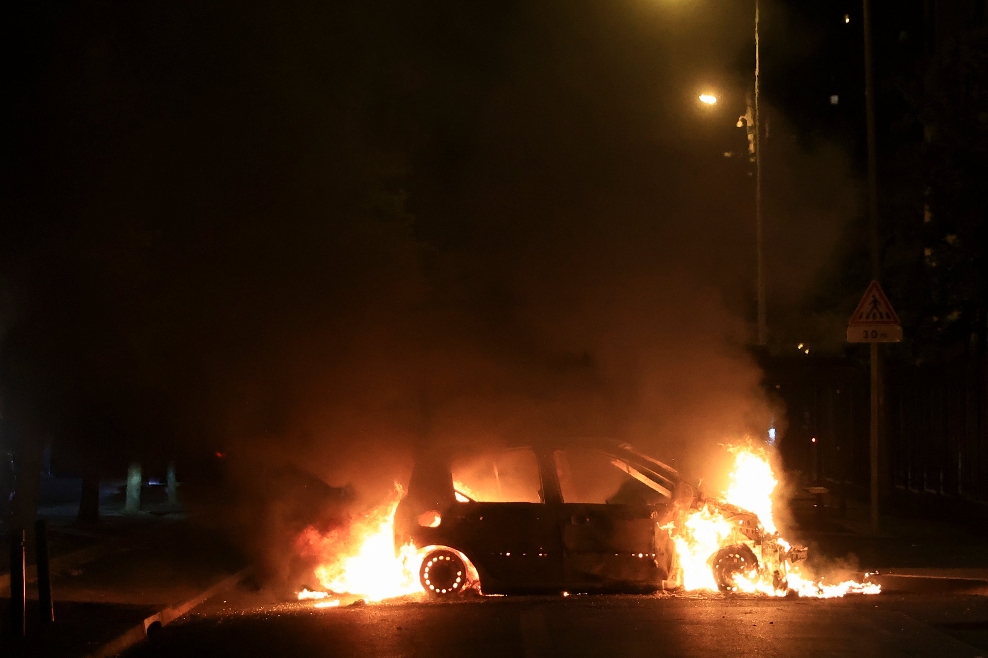 A car burns during protests sparked by the fatal police shooting of a 17-year-old driver