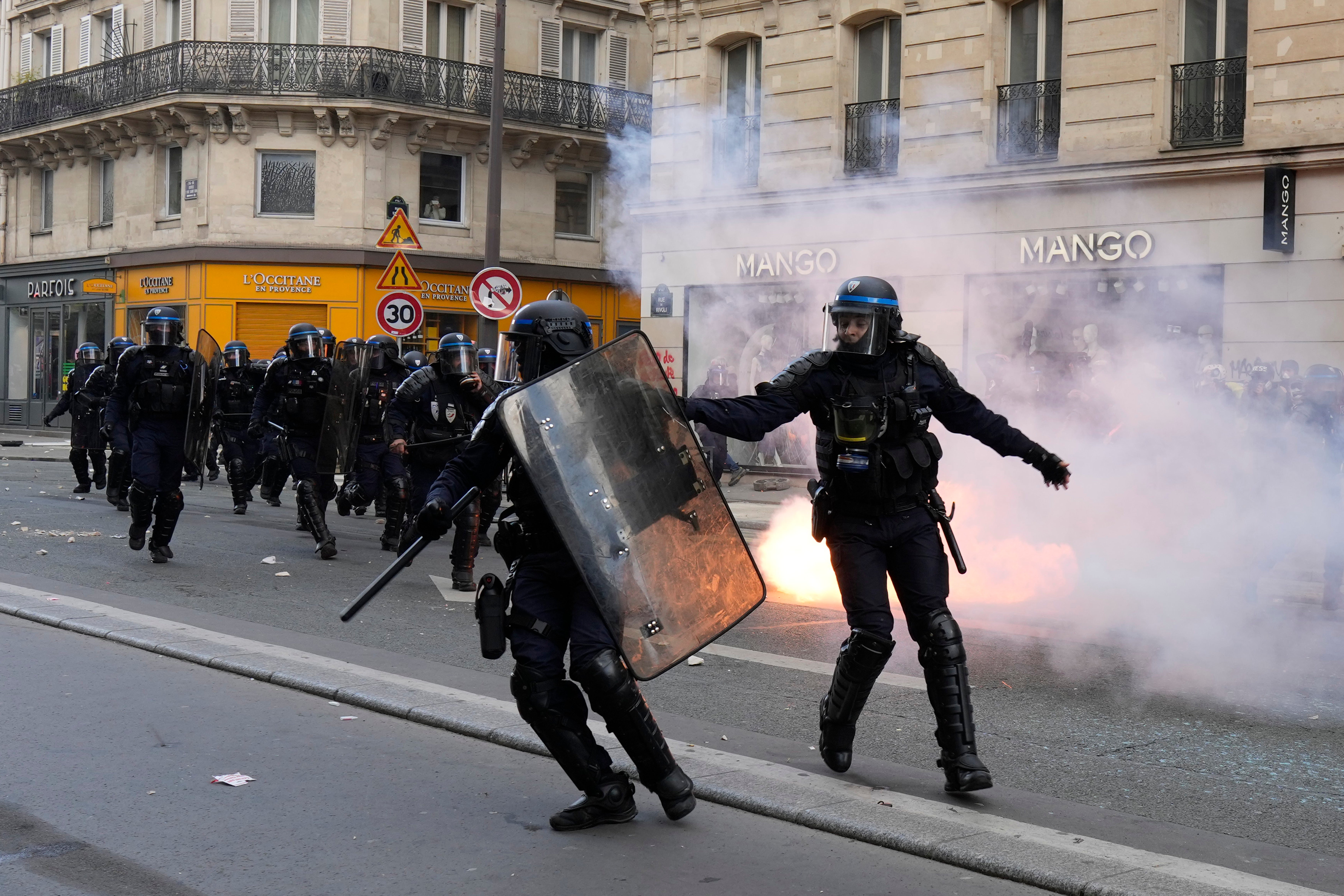 Riot police officers charge youths during a demonstration