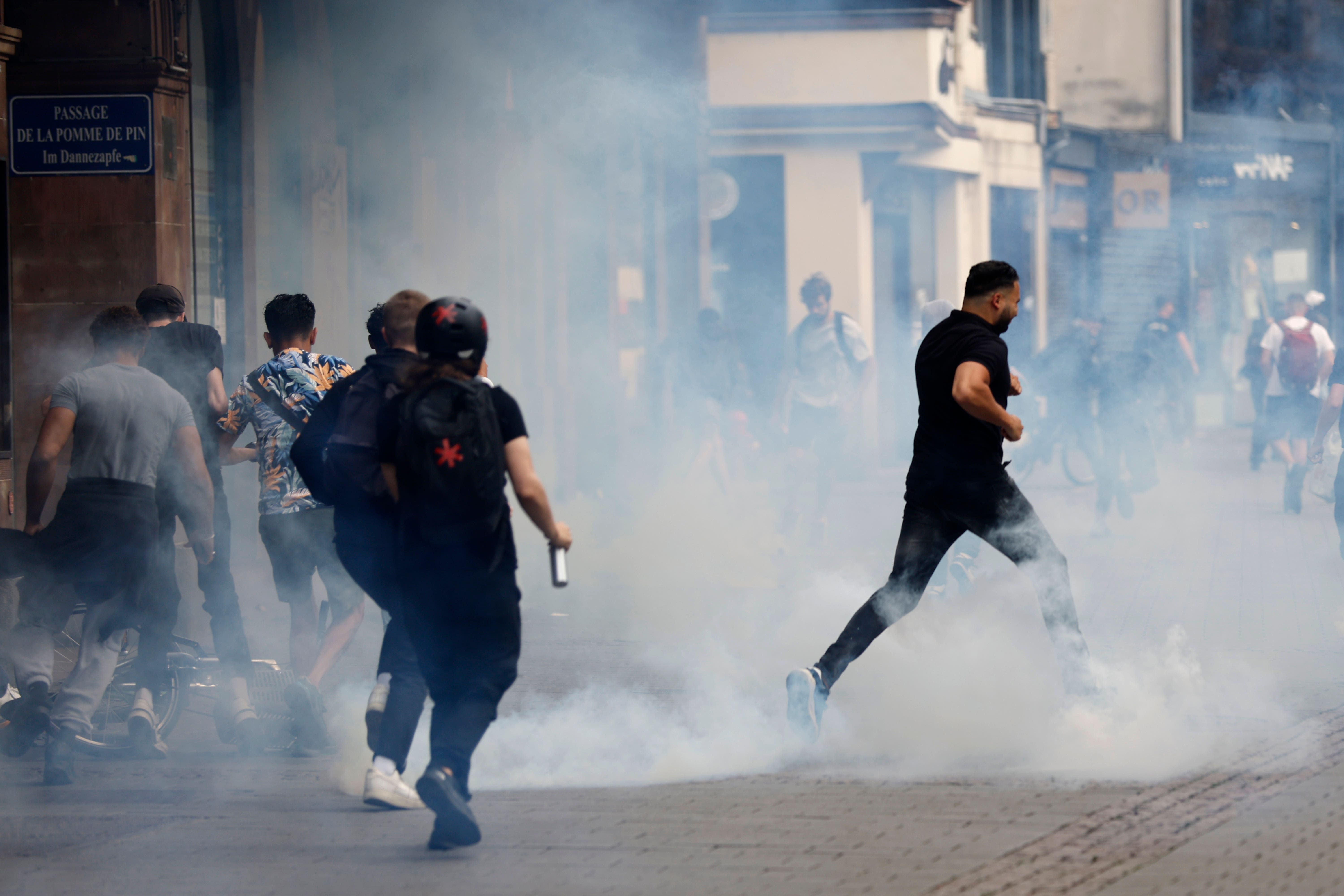 Youths run away during a protest in Strasbourg, eastern France (Jean-Francois Badias/AP)