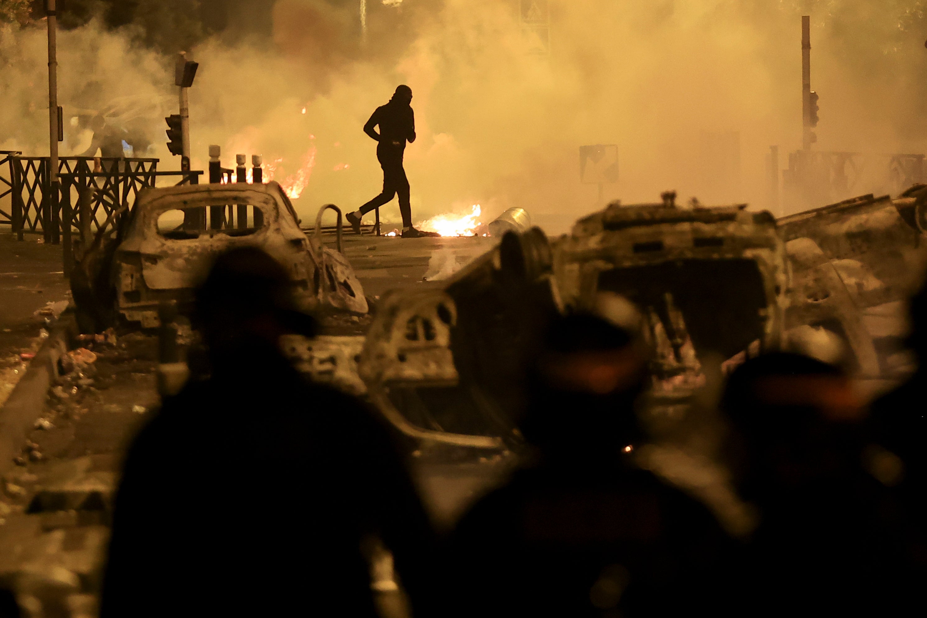 A demonstrator runs amid the protests sparked by the fatal police shooting of a 17-year-old driver in the Paris suburb of Nanterre