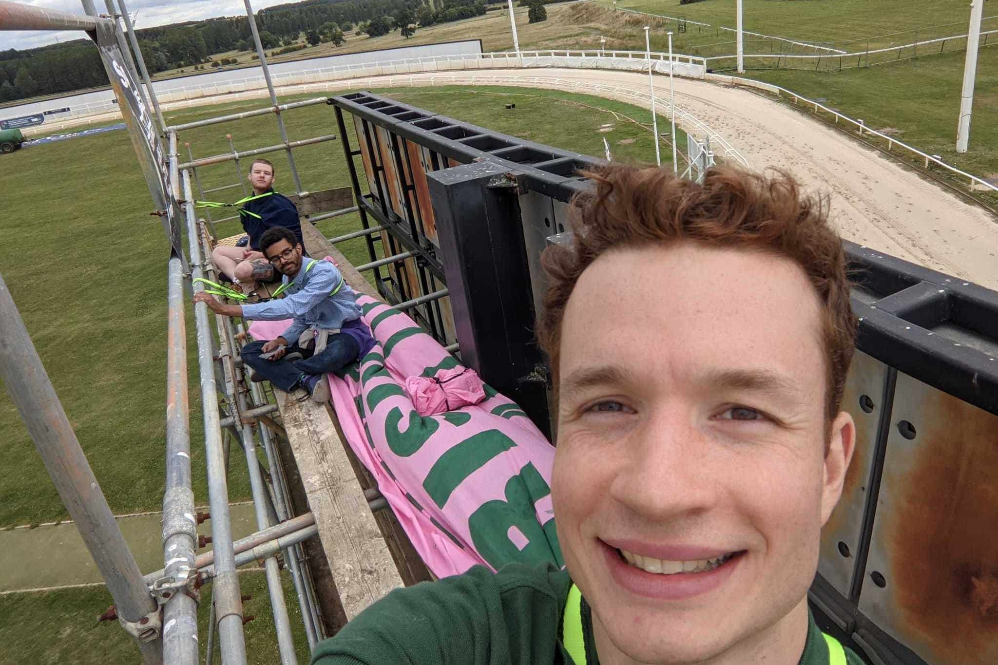 Animal rights activists scaled scaffolding holding a large TV screen in the centre of the greyhound racing track at Towcester (Animal Rising/PA)