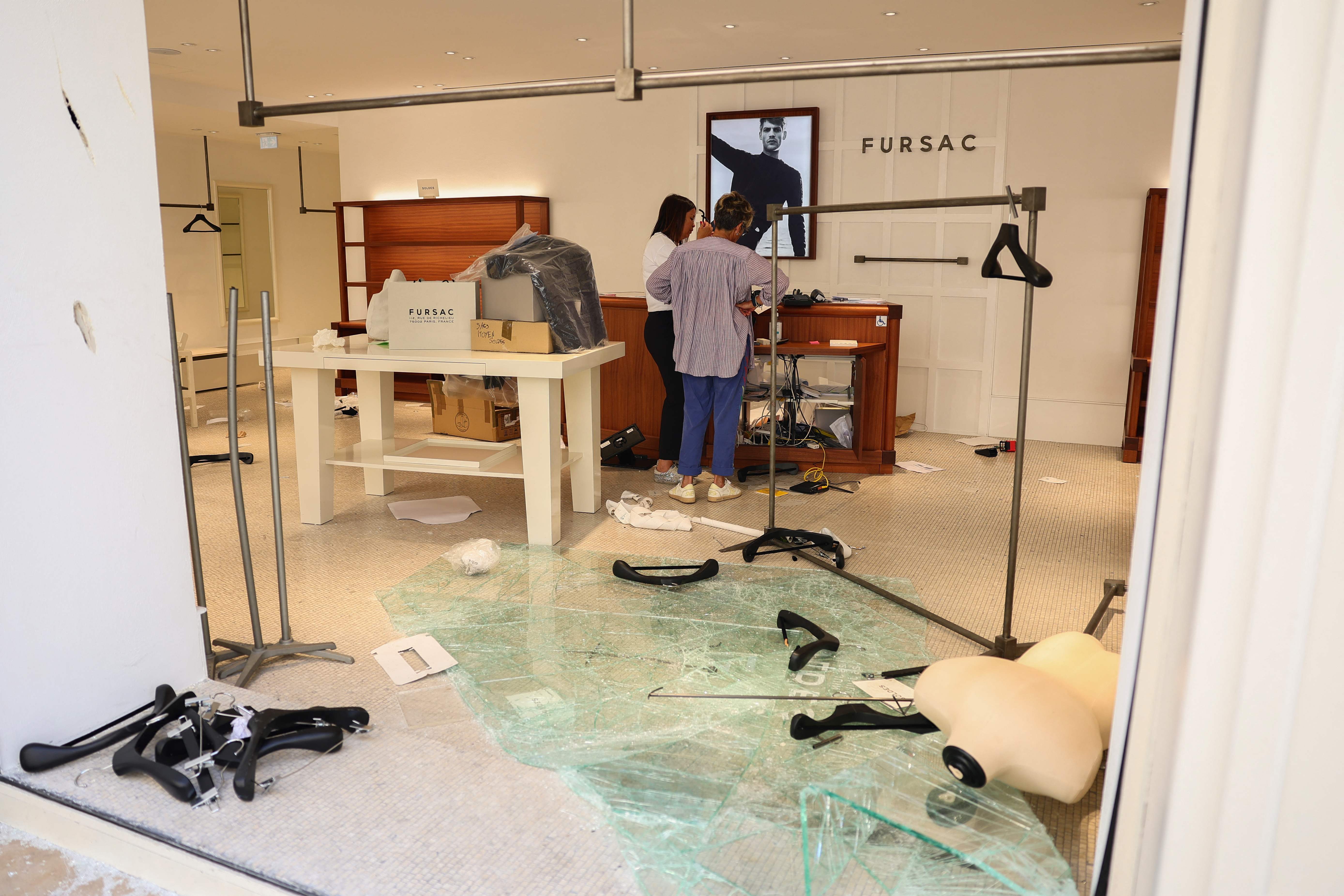 Employees examine a damaged Fursac shop in the centre of Marseille, southern France on Saturday