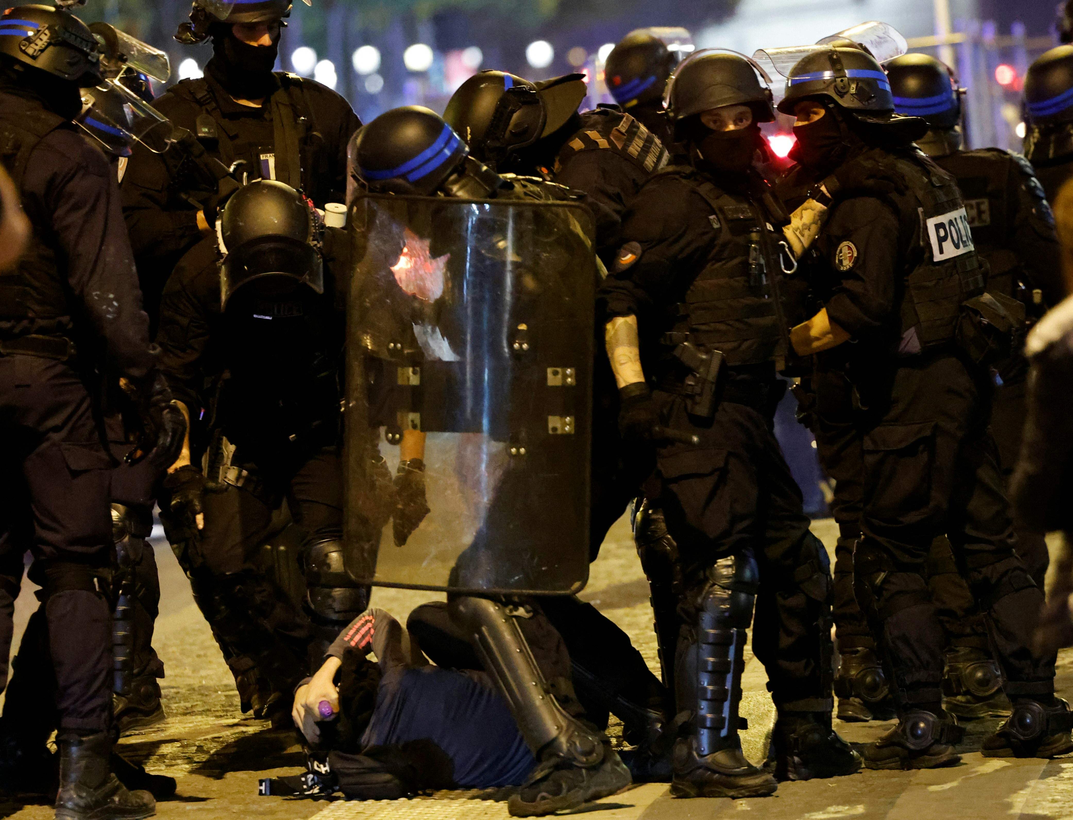 French police officers detain a demonstrator in Paris