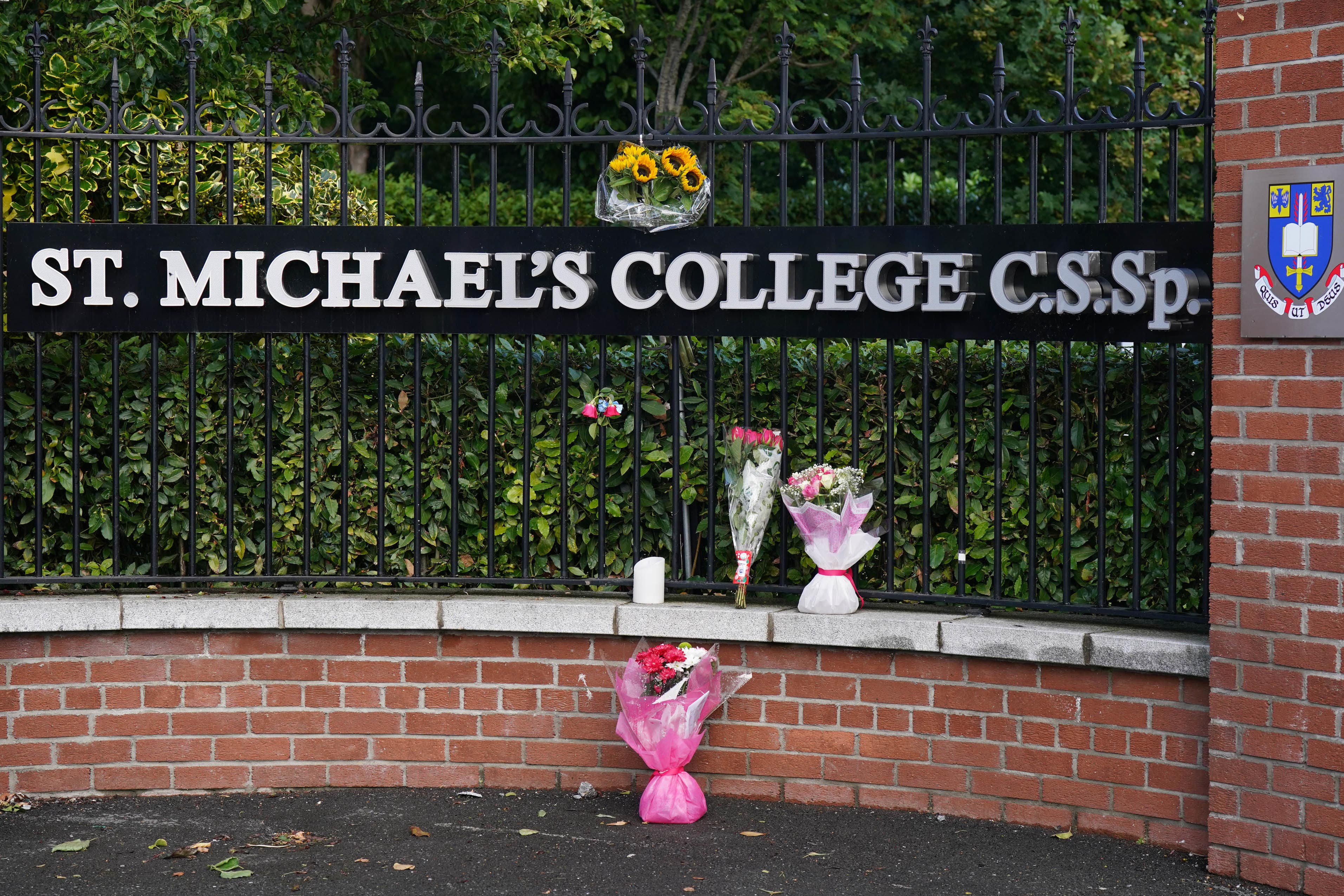 Flowers outside St Michael’s College in Dublin after the deaths of two recent graduates on the Greek island of Ios (Niall Carson/PA)