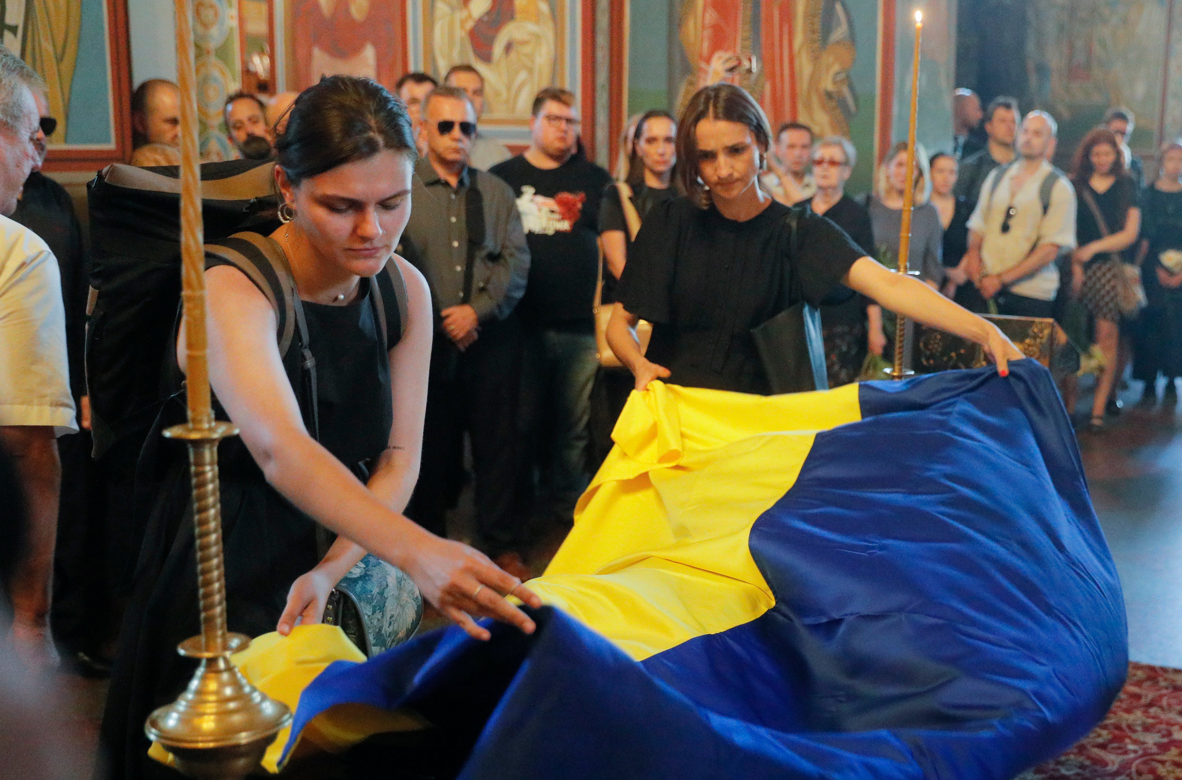 Mourners cover the coffin of Victoria Amelina at St. Mykhailivsky Cathedral in Kyiv on Tuesday