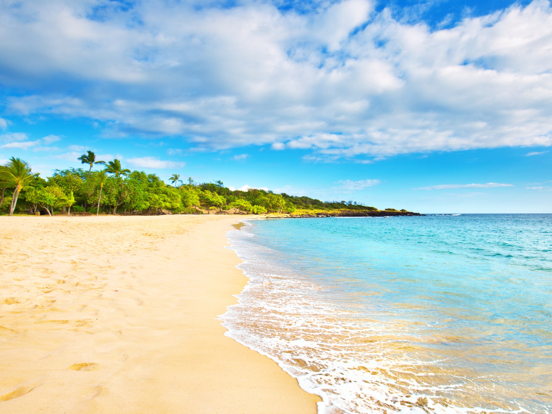 The unspoilt bay has tidal pools made of volcanic rock