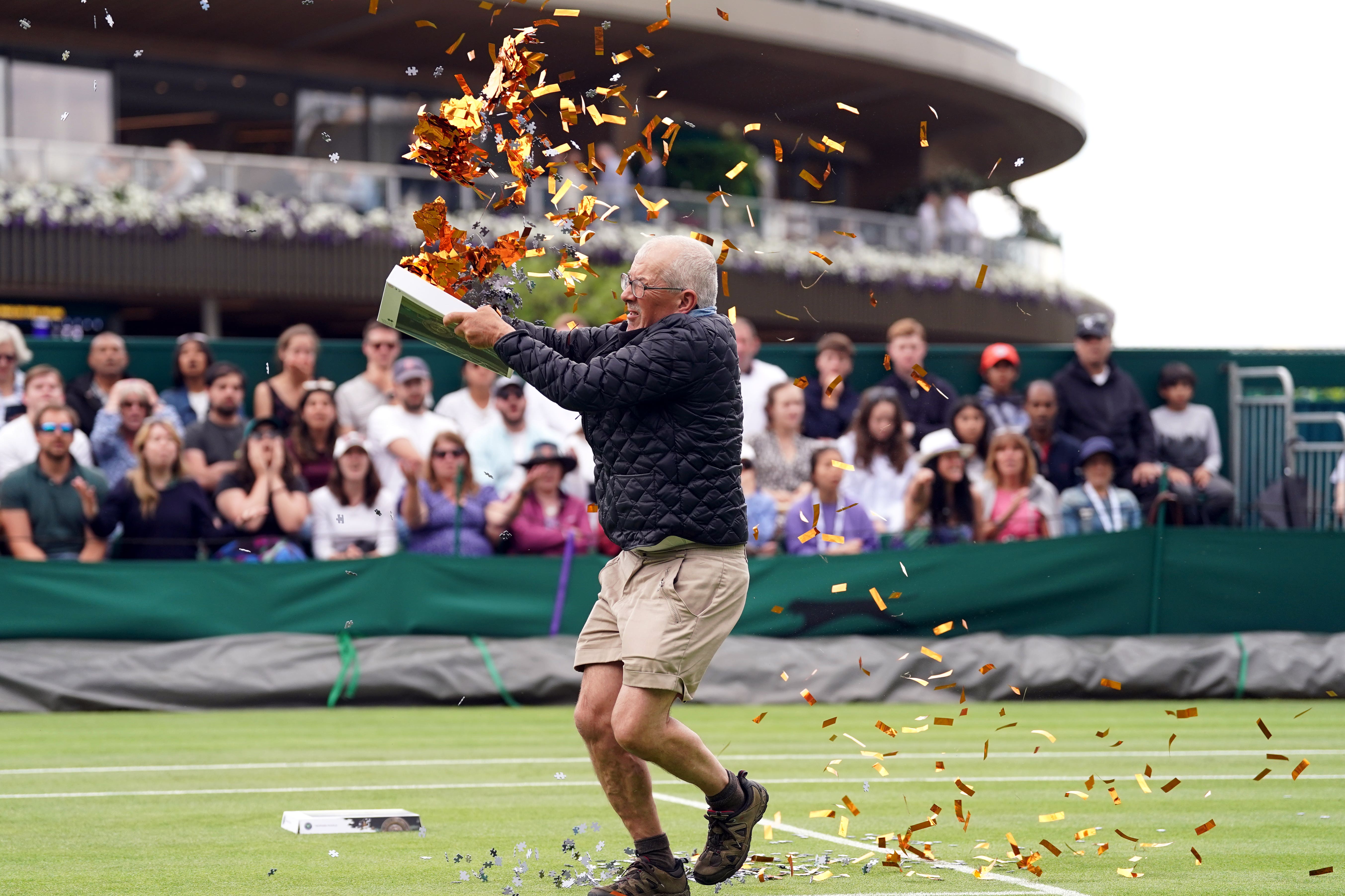 A Just Stop Oil protester threw orange confetti and jigsaw puzzle pieces on to court (Adam Davy/PA)