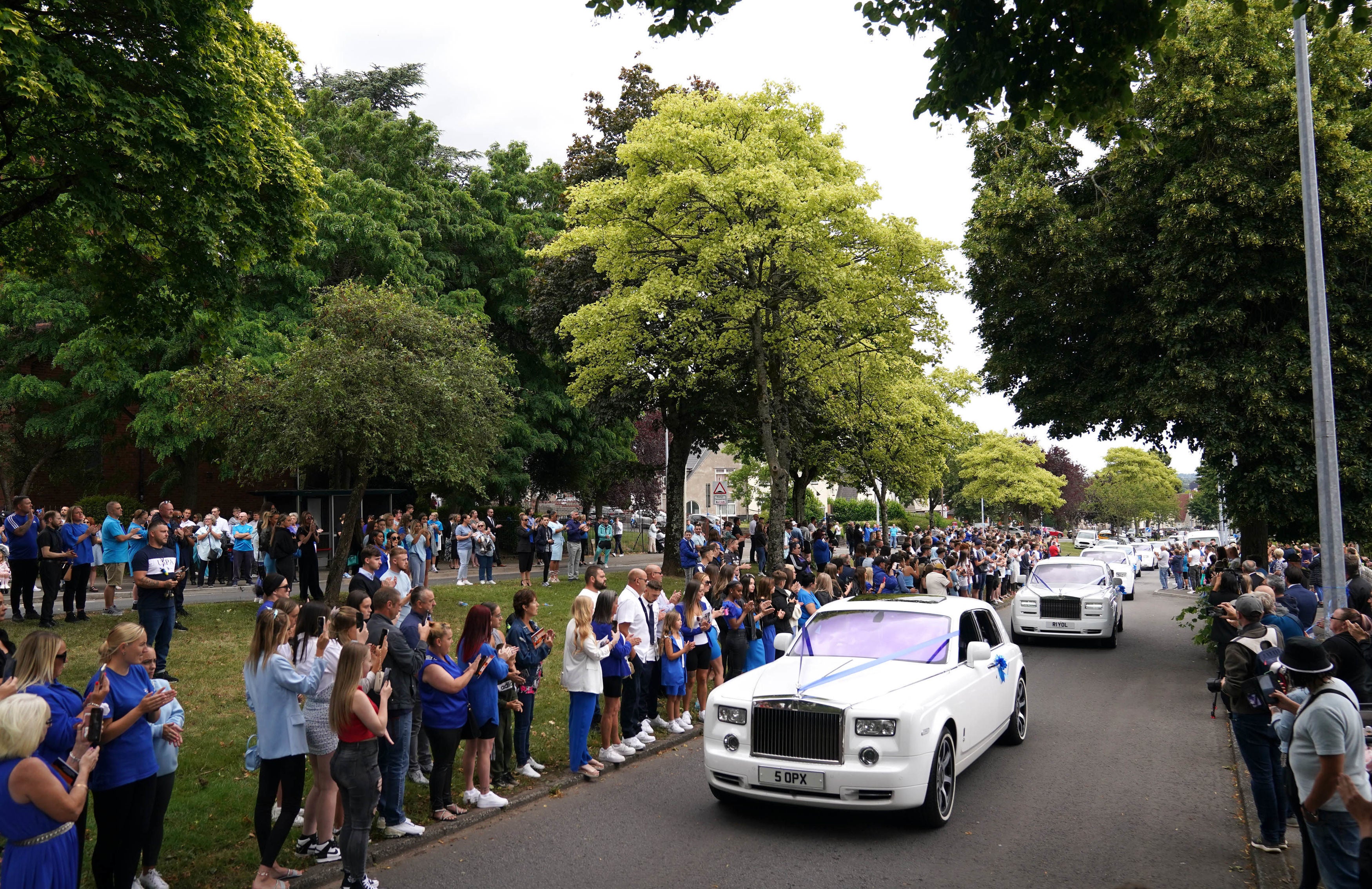 Mourners line the street as the funeral cortege of Kyrees Sullivan and Harvey Evans arrives at the Church of the Resurrection in Ely, Cardiff