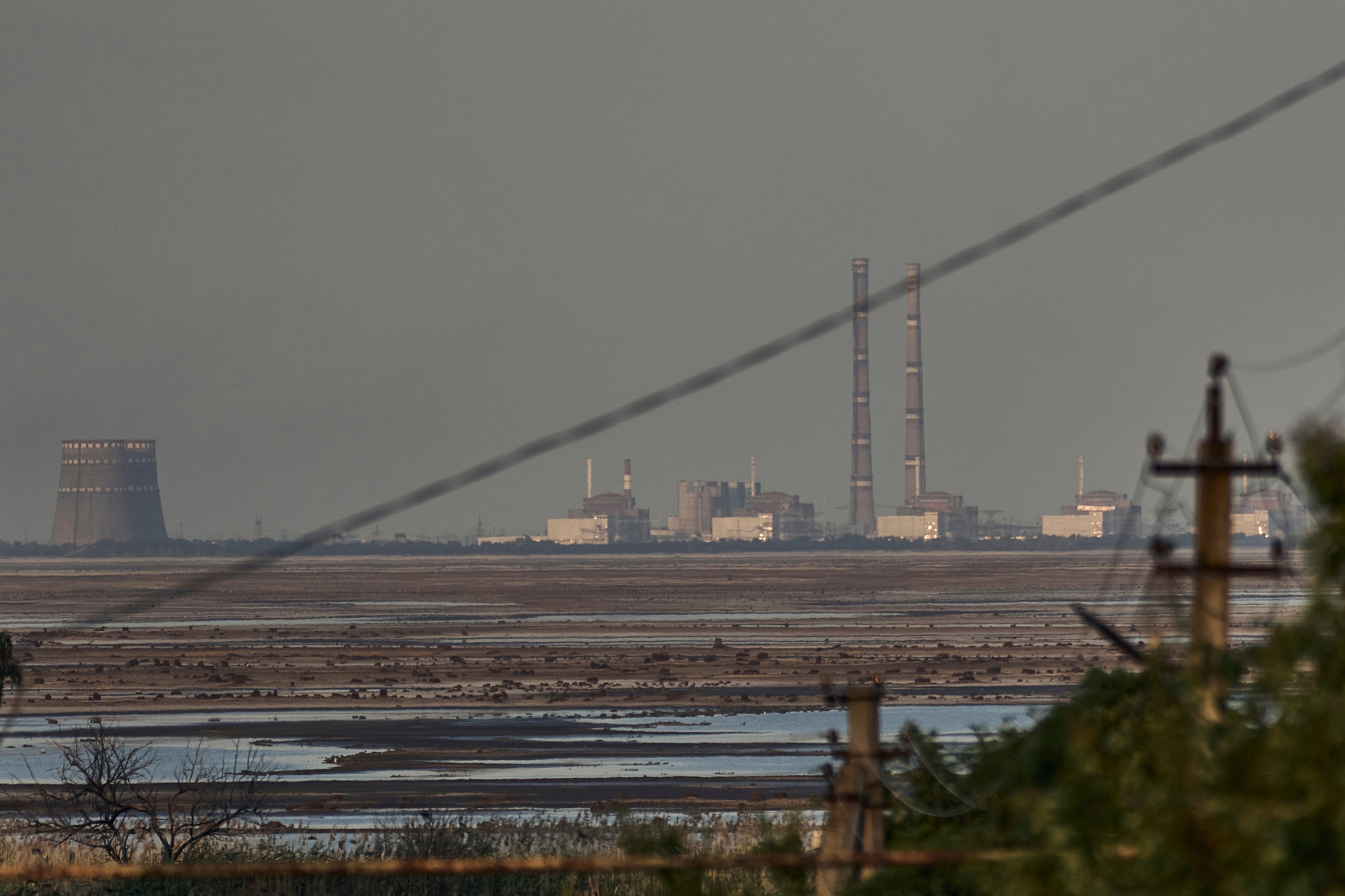 The Zaporizhzhia nuclear power plant, Europe's largest, is seen in the background of the shallow Kakhovka Reservoir