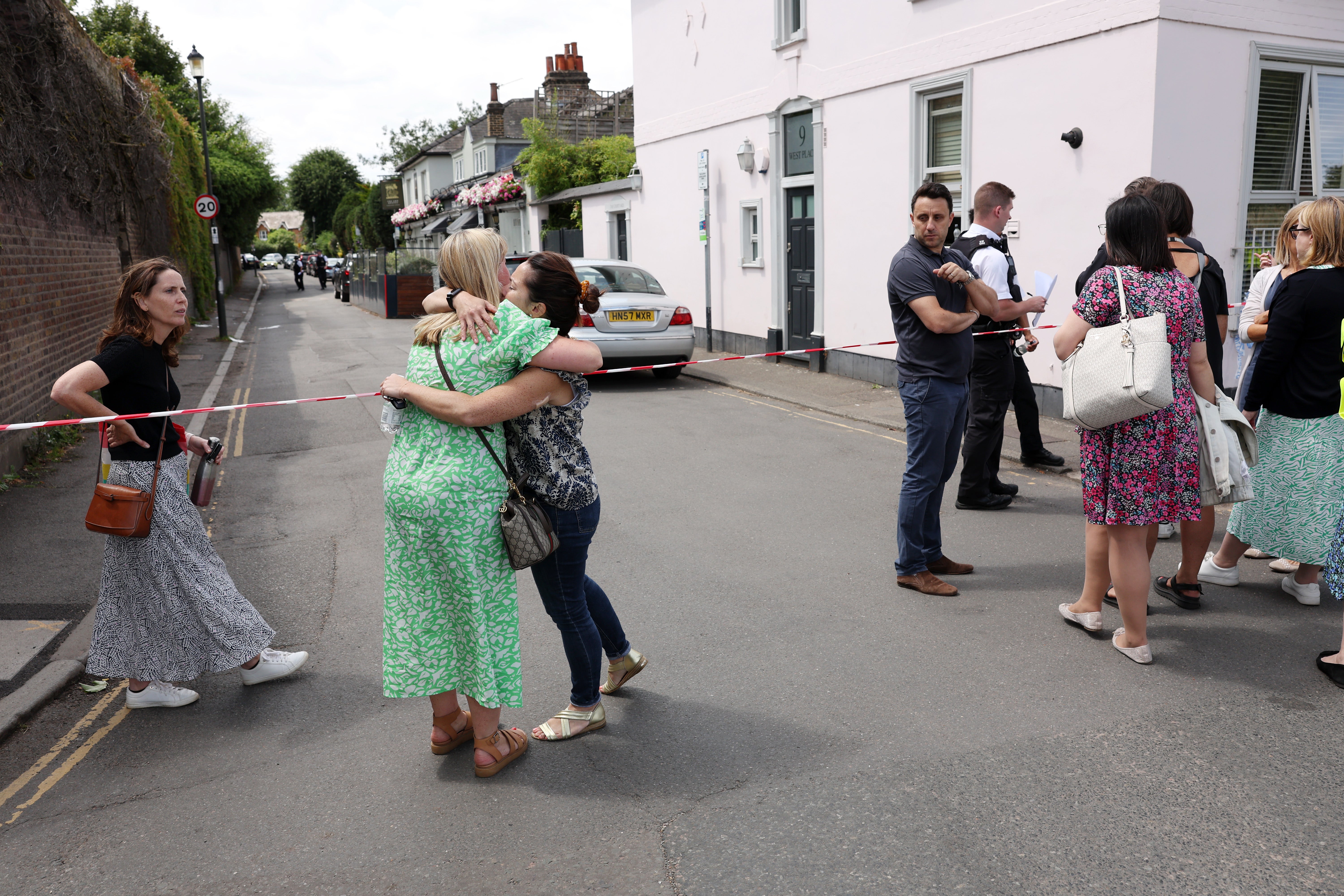 People gather outside the cordon at the scene of the car crash at the Wimbledon school