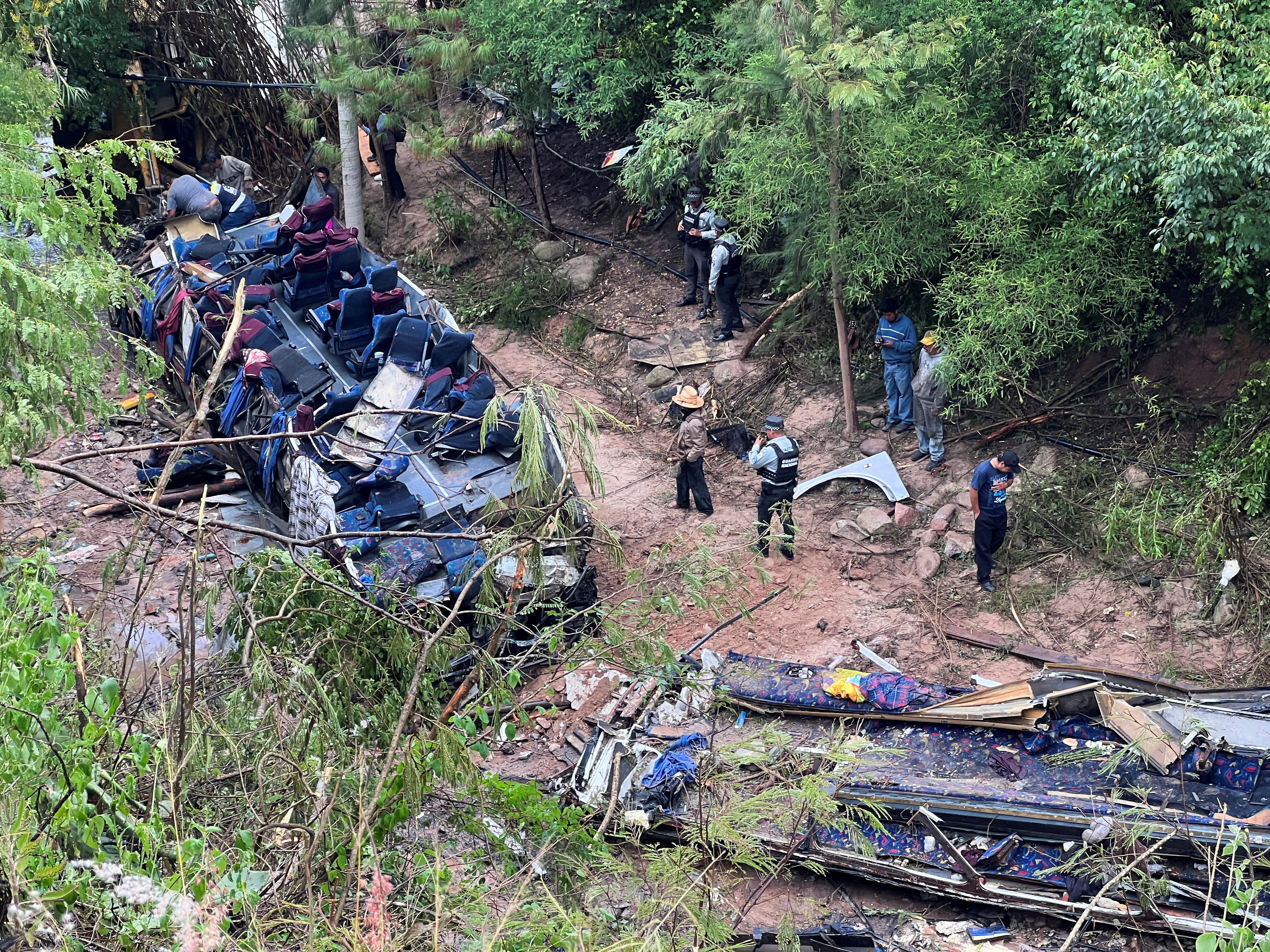 Authorities and volunteers work at the site of the bus crash