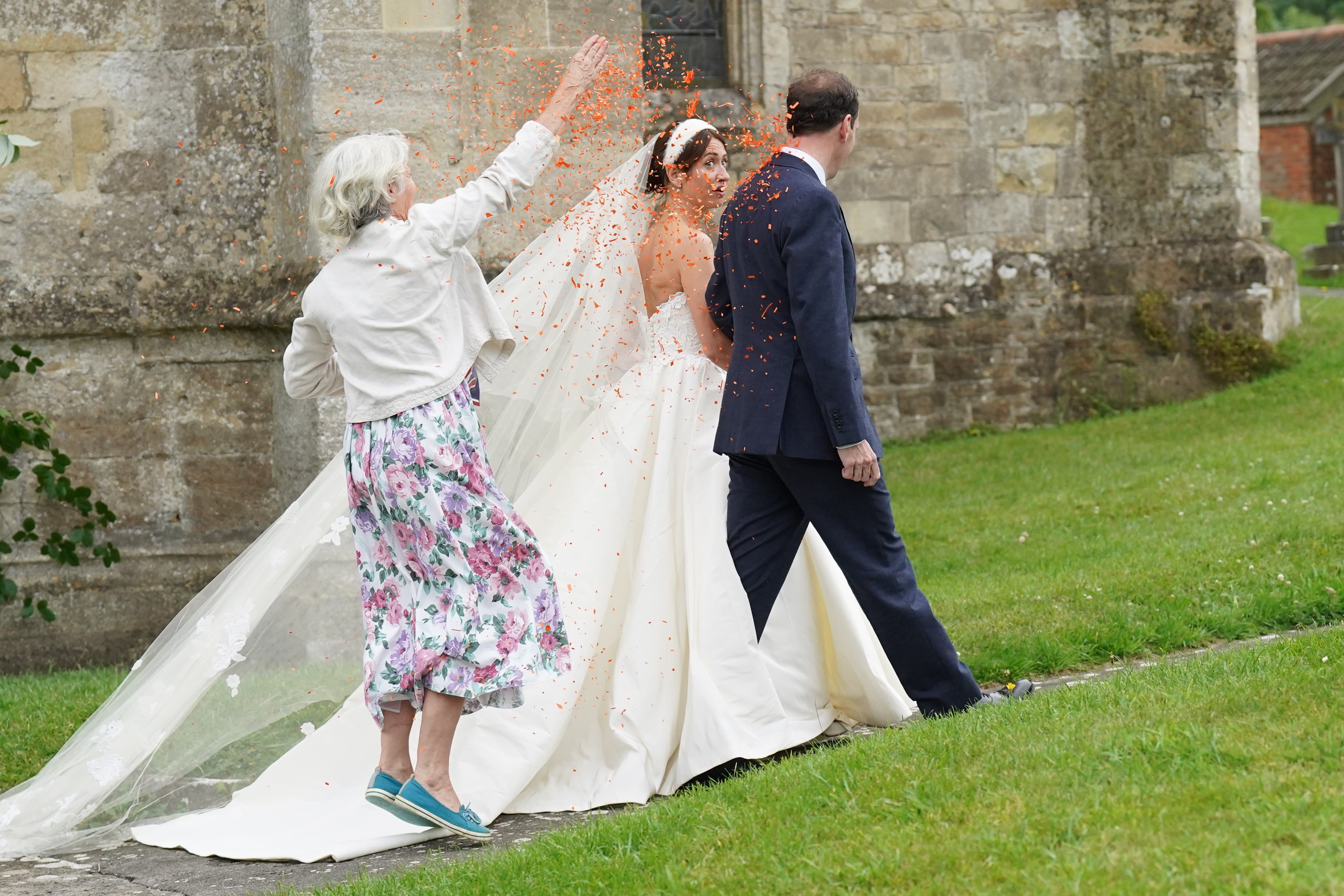 A woman believed to be a Just Stop Oil protester throws orange confetti over former chancellor George Osborne and his wife Thea Rogers (Stefan Rousseau/PA)