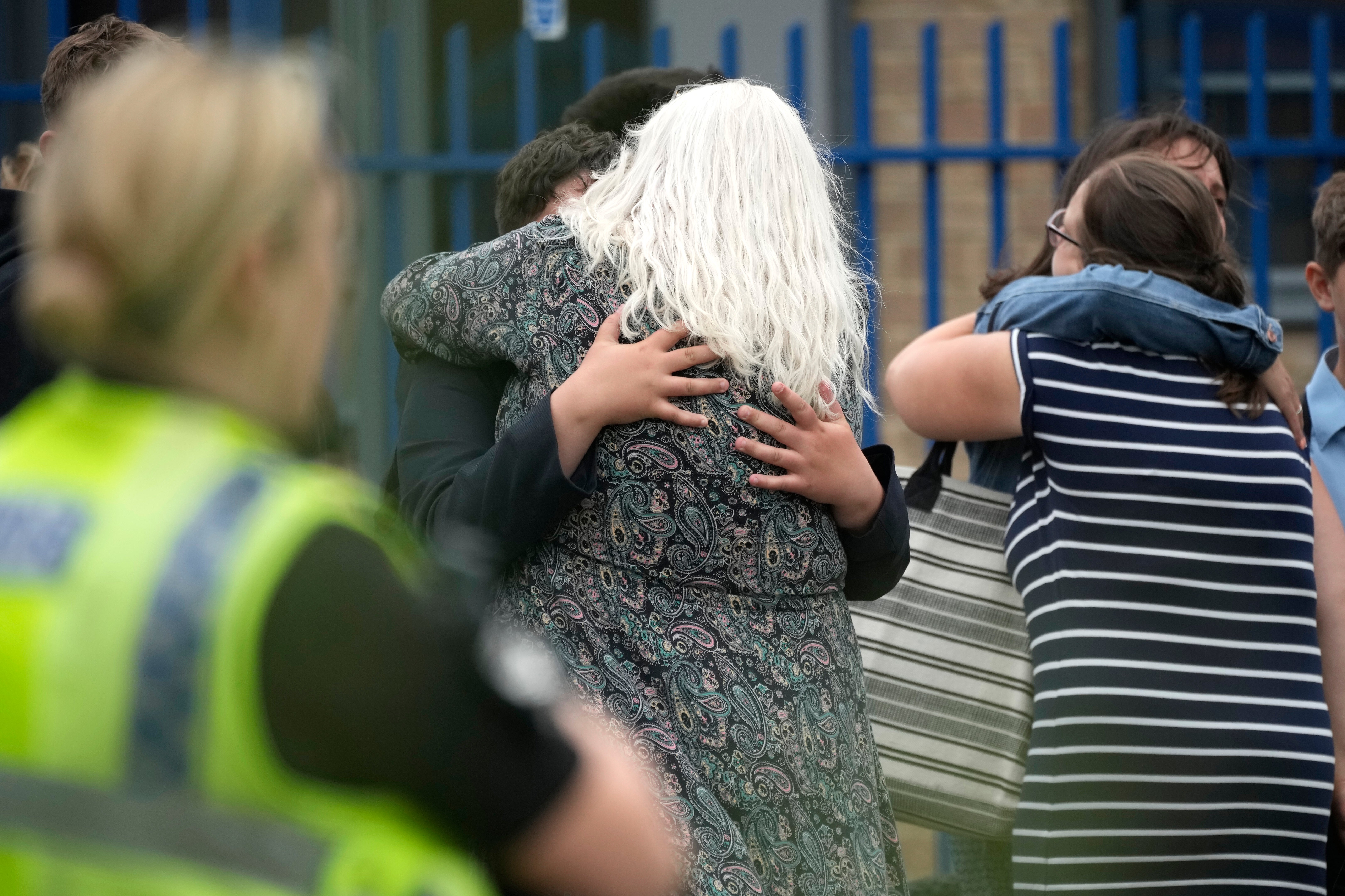 People embrace outside Tewkesbury School after a teenage boy was arrested following a stabbing