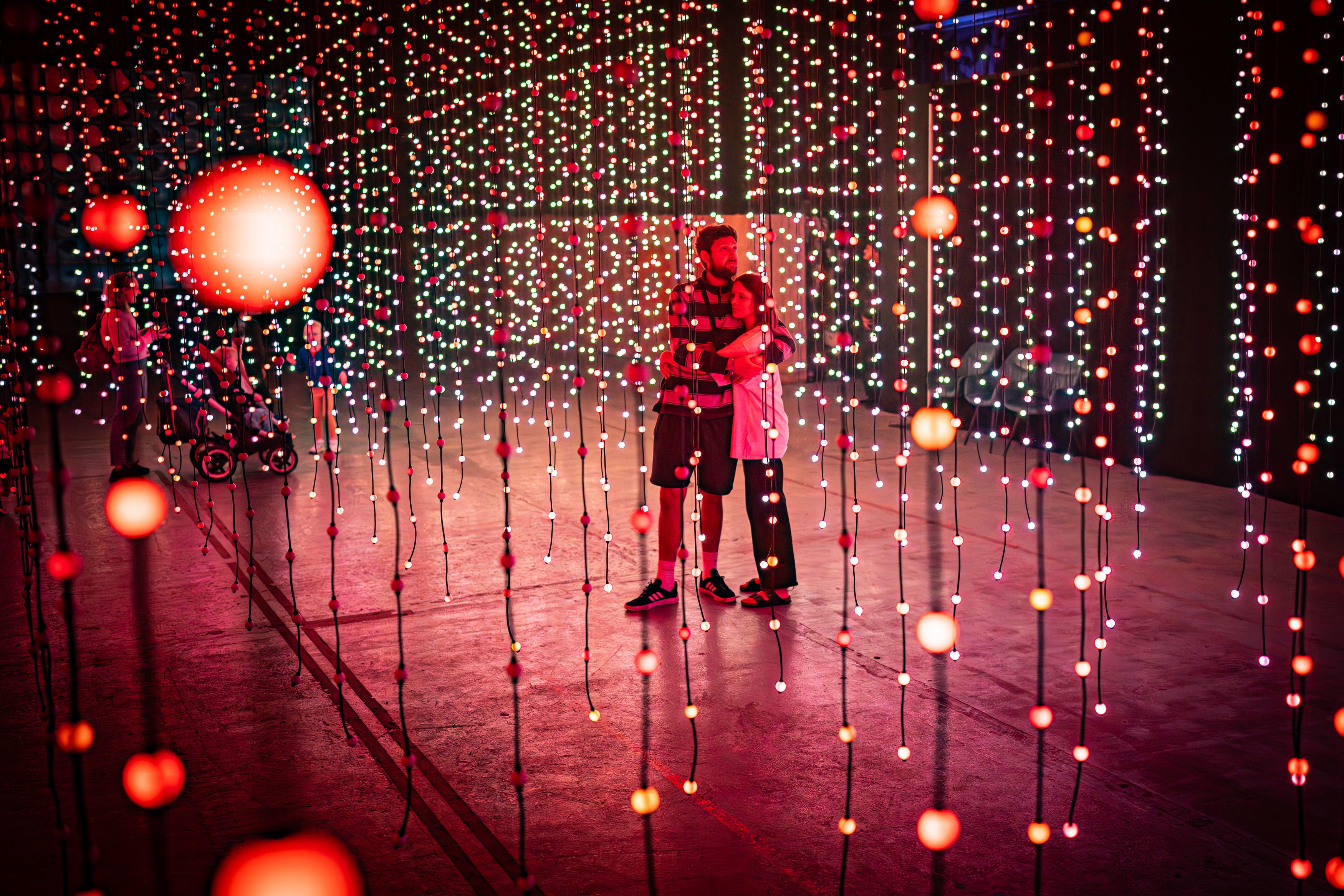 People hug as they admire Submergence inside Propyard, Bristol, where a 20,000 sq ft immersive art installation, curated by art collective Squidsoup, titled Beyond Submergence, is being exhibited