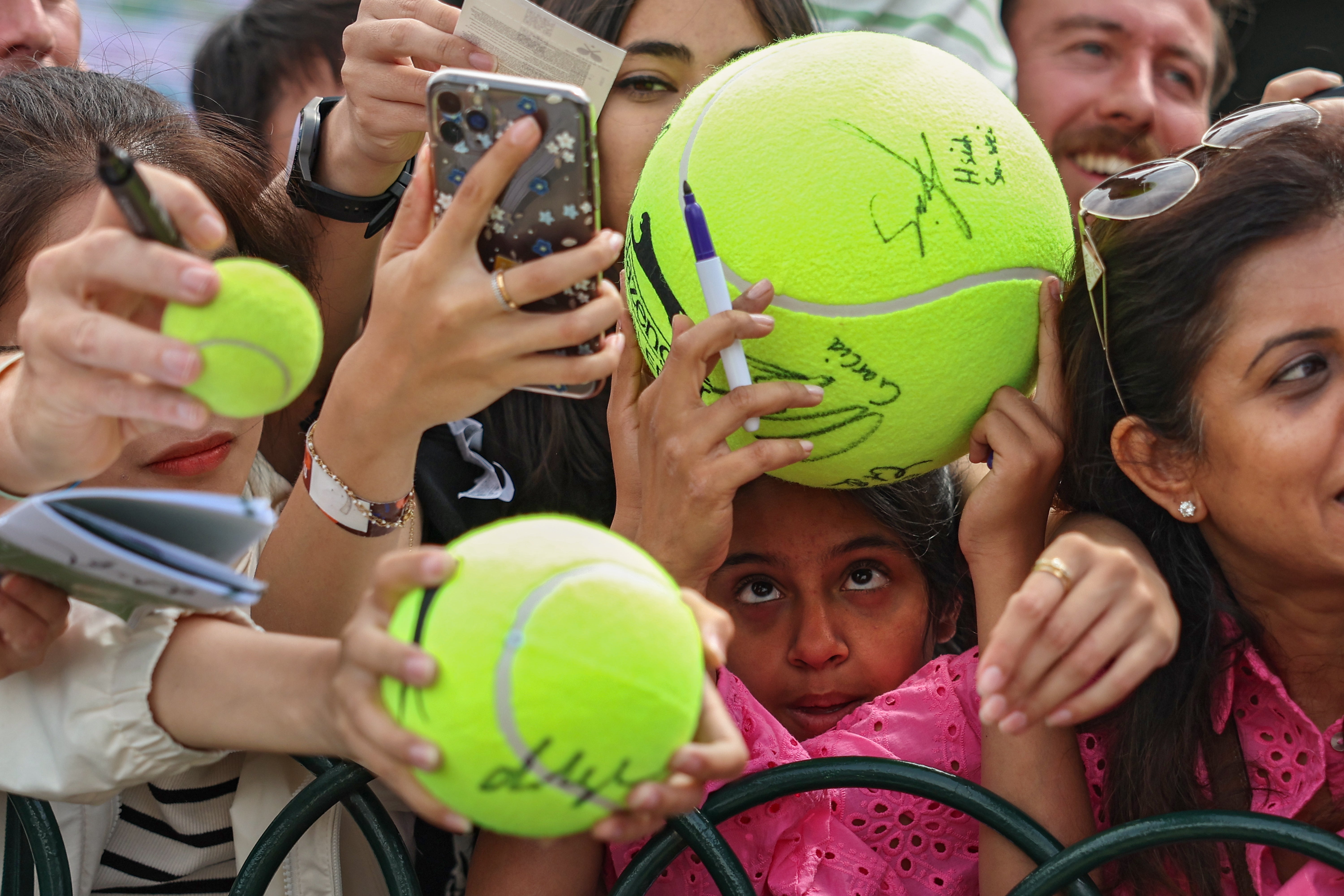 Fans attempt to get autographs and pictures near the practice courts at Wimbledon