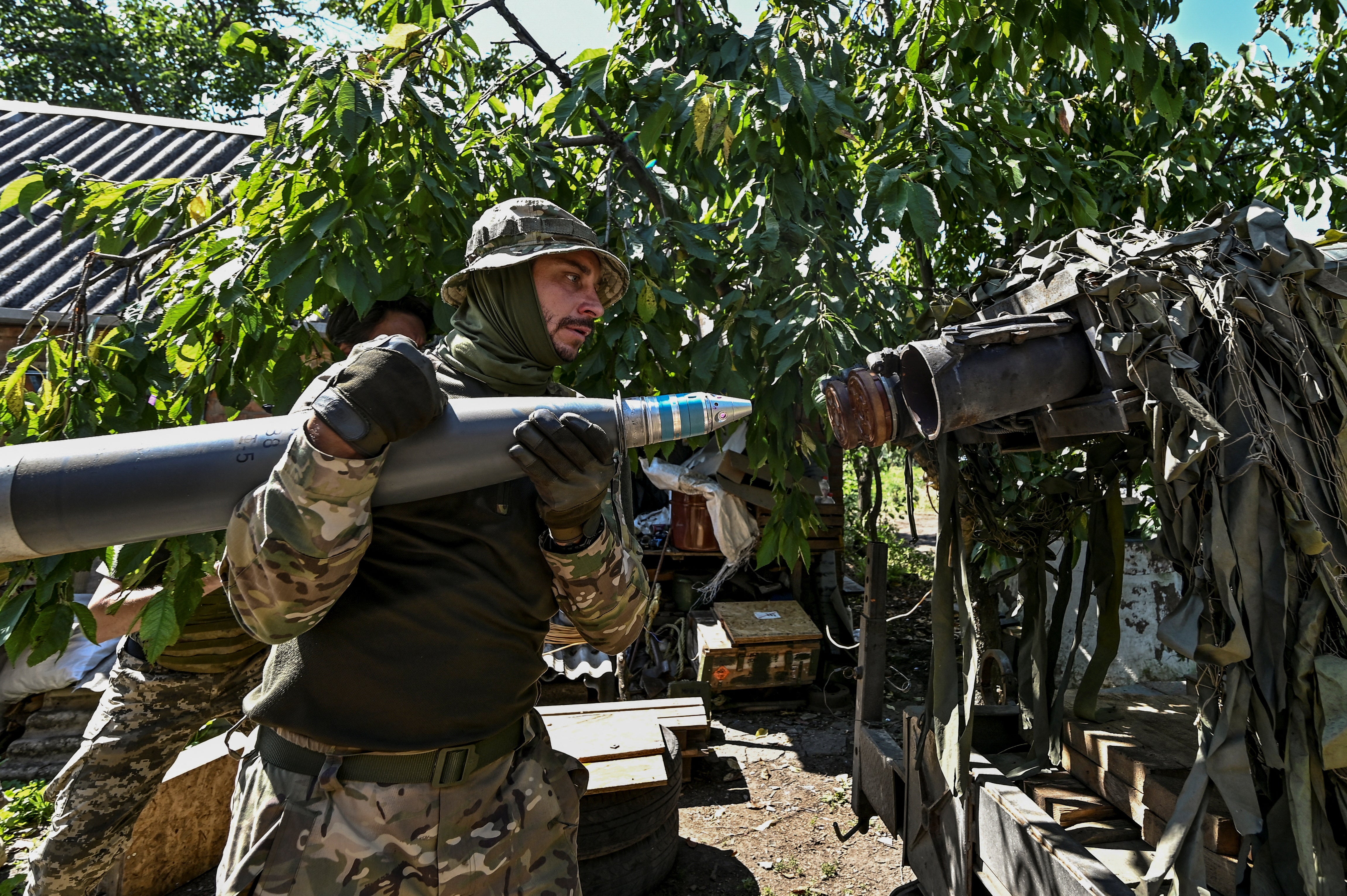 Ukrainian servicemen load a shell into a Partyzan small multiple rocket launch system before firing toward Russian troops at a position near a front line in Zaporizhzhia region