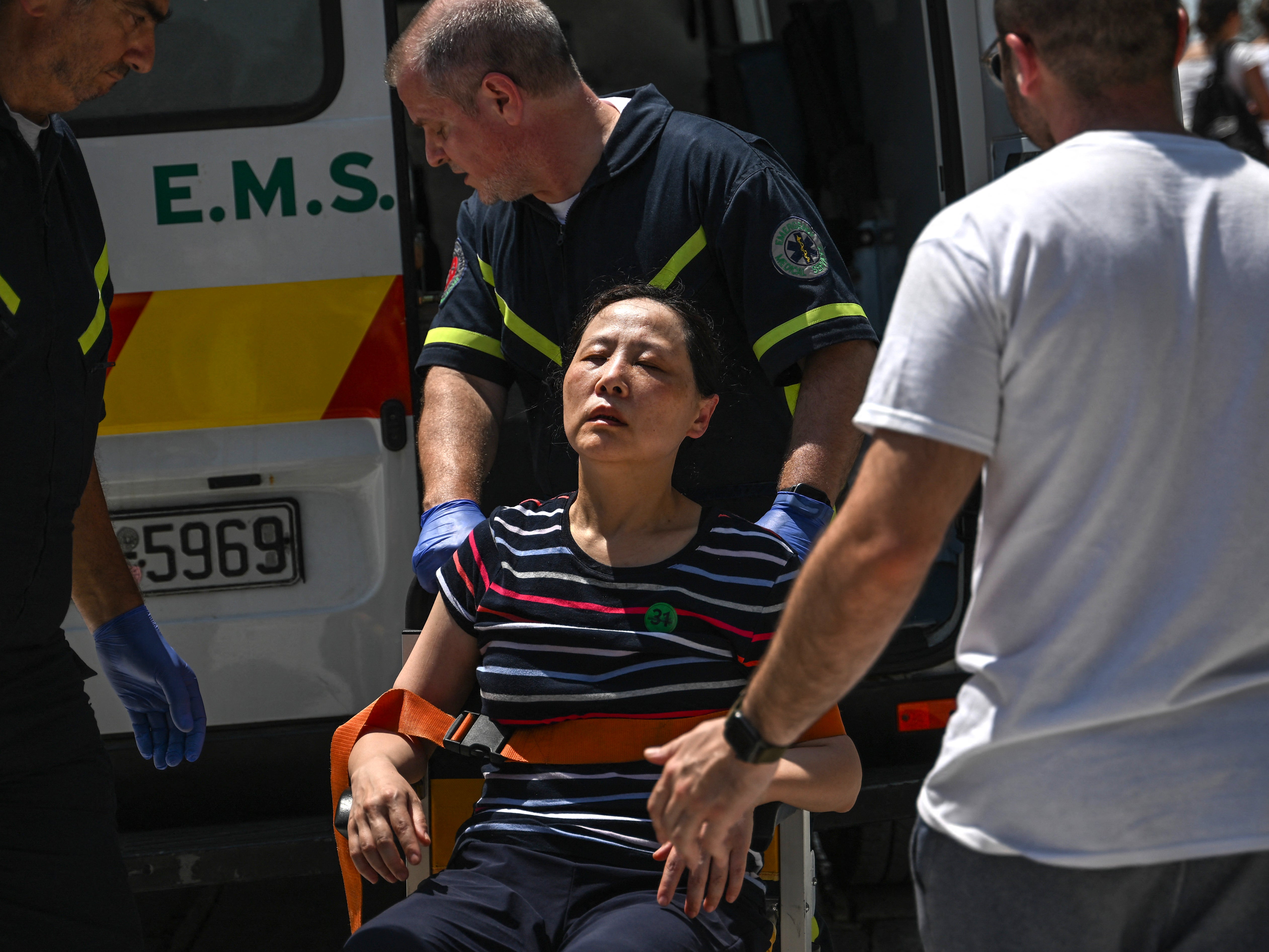 Rescue workers take a visitor from the Acropolis to an ambulance