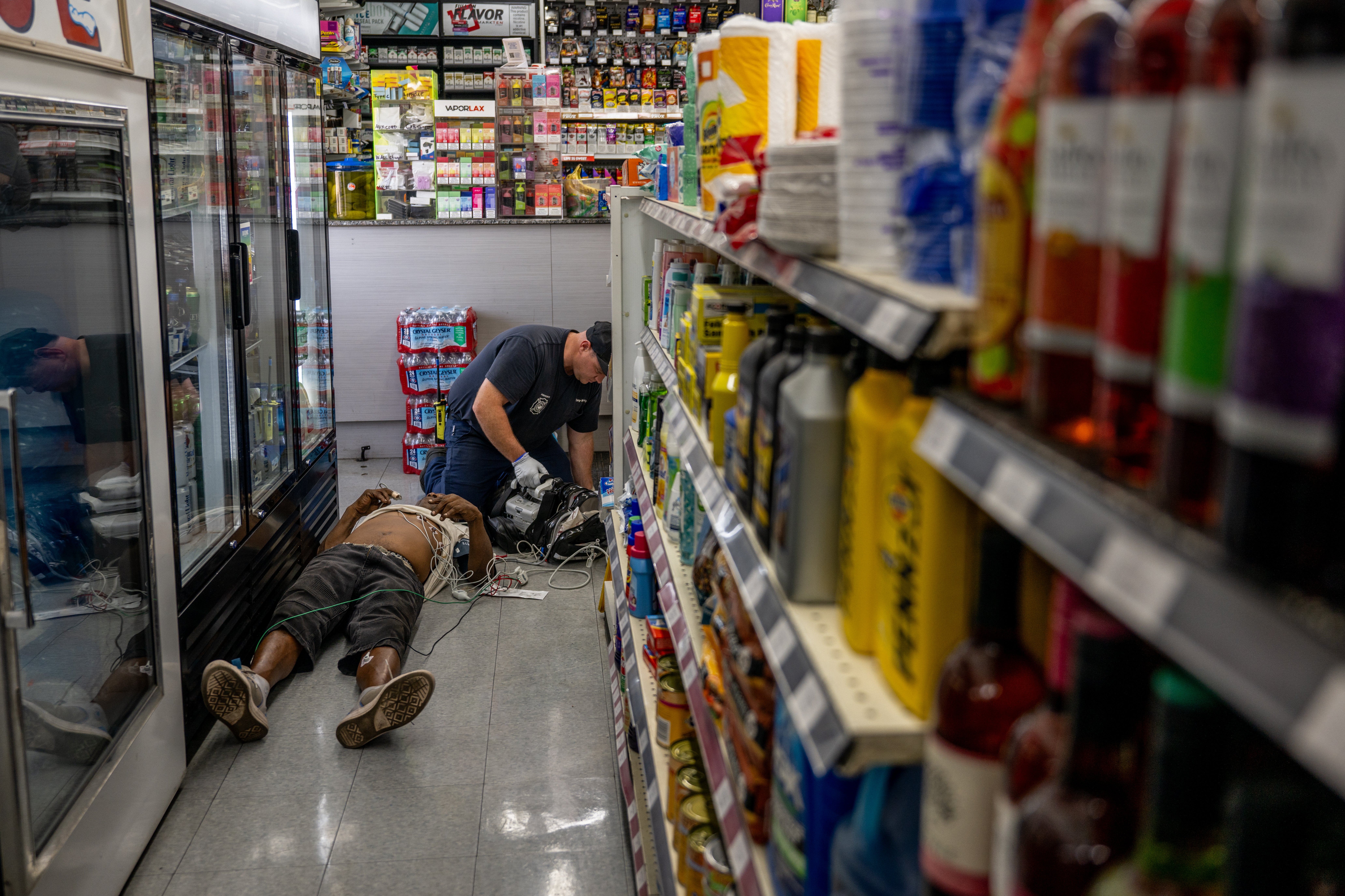 A person receives medical attention after collapsing in a convenience store on July 13, 2023 in Phoenix, Arizona. Temperatures have remained at 110F for two weeks