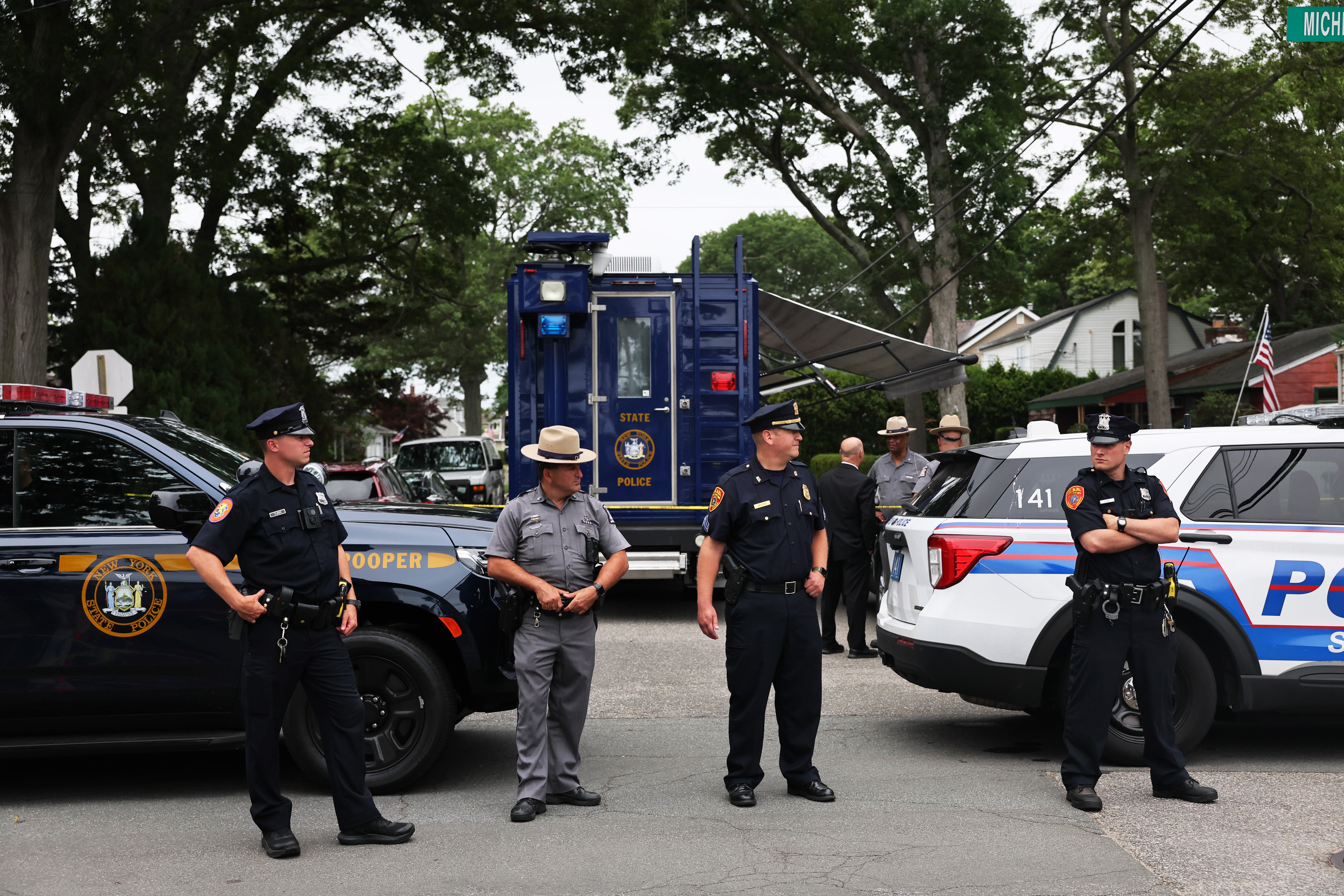 Law enforcement officials at the home of the suspect arrested in the unsolved Gilgo Beach killings